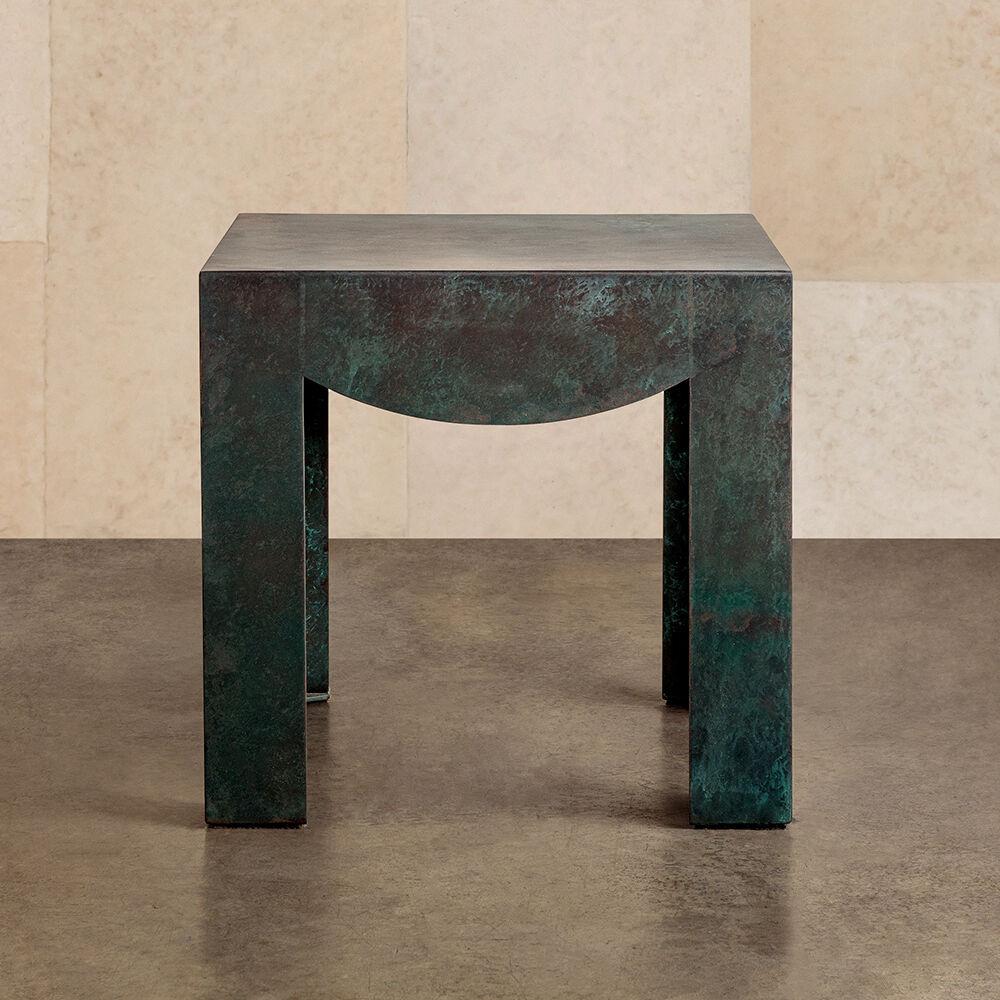 The Pelle side table pairs crisply symmetrical lines with sculptural quality, synchronously highlighting the beauty of its natural patina. This metal table is handcrafted by local artisans from ¼