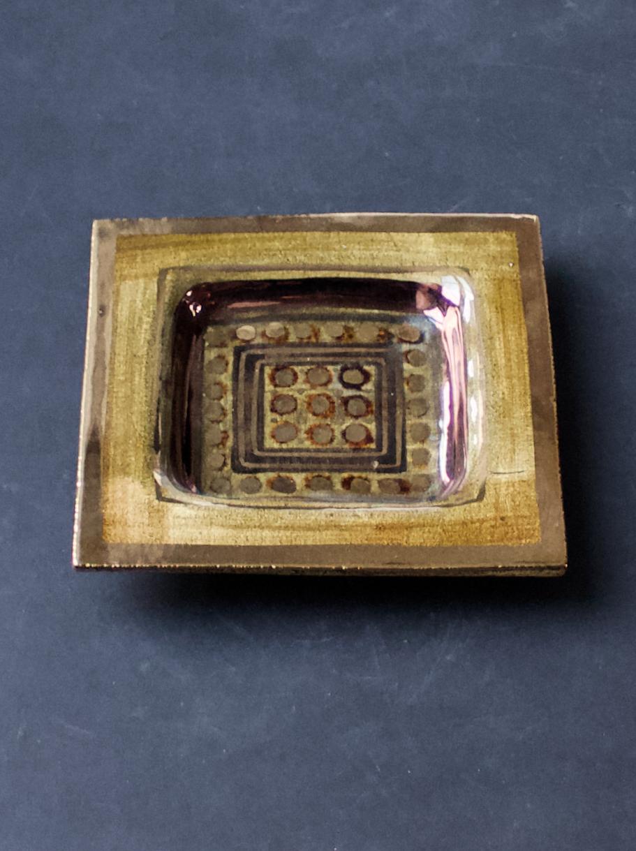 Decorative plate or vide-poche by ceramicist Georges Pelletier, France.

Handmade ceramic, with an attractive design in deep gold and pewter tones, with gold and copper lustre details. The piece is glazed with a glossy craquelure finish. Mounted