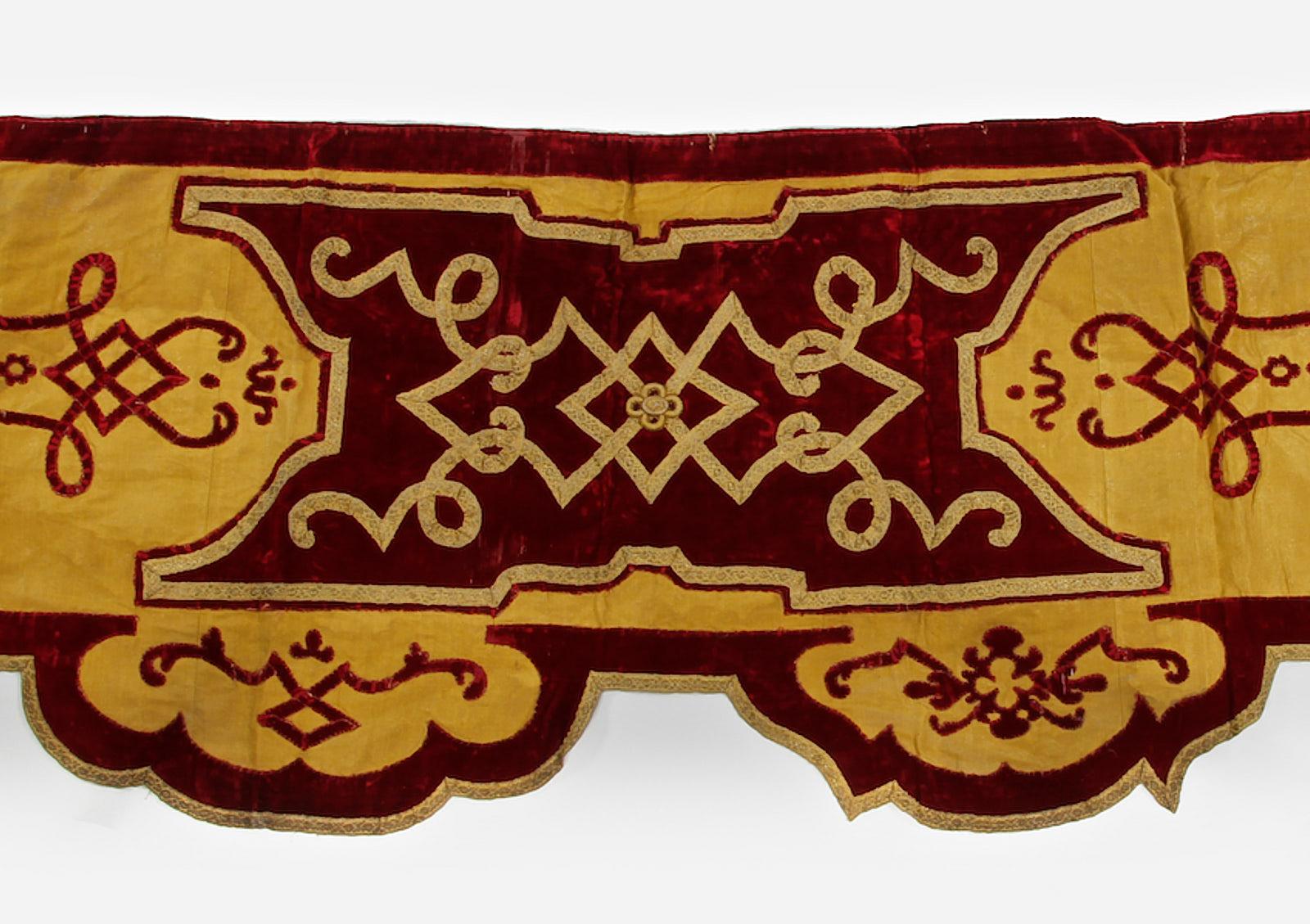 Late 19th century velvet and lame’ curtain pelmet, English, Holland House, London, circa 1860-1890.

The section of curtain pelmet in renaissance style, centred by a crimson velvet cartouche with gold braid strap-work, flanked by lame’ panels with