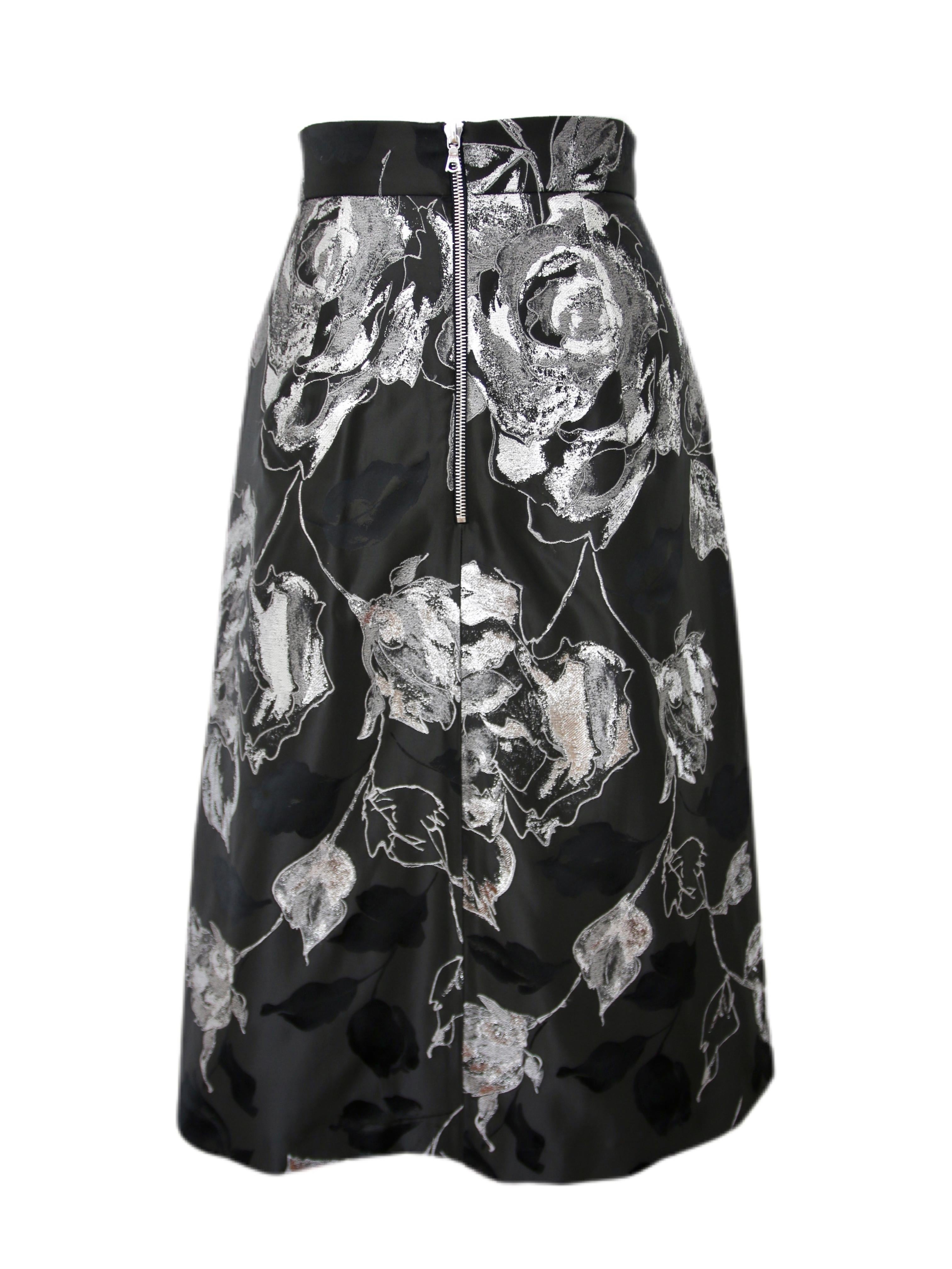 La gonna Pelush in broccato floreale nero e argento è un pezzo unico ed esclusivo. Caratterizzato da un romantico tessuto di seta Couture italiano con fiori e foglie metallizzati e sfumature ombreggiate, questo bellissimo capo può essere indossato