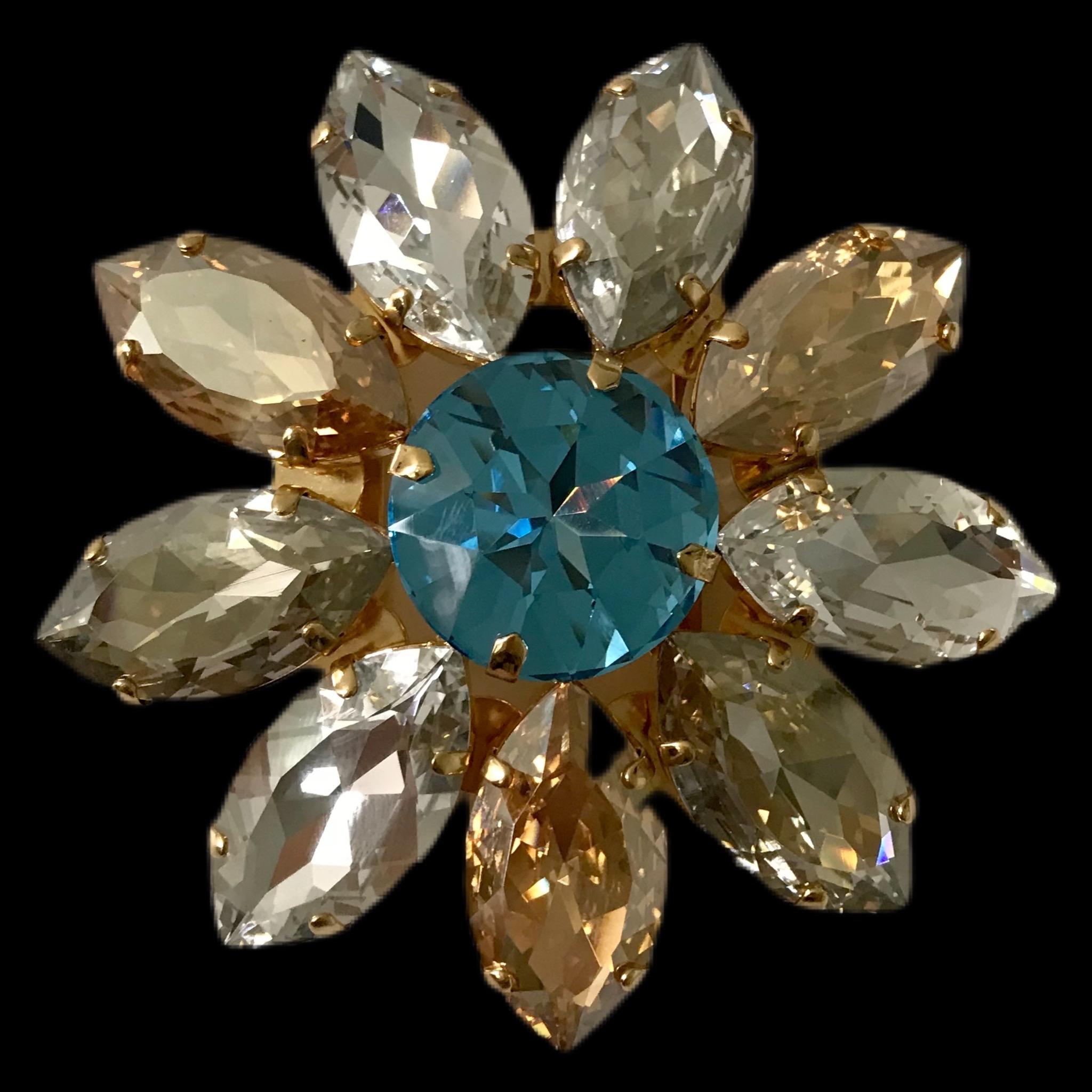 The Pelush blue and amber Swarowsky crystal flower brooch is a one of a kind exclusive piece. Made for Pelush by Florentine artisans in Italy, this striking statement jewelry can be utilized in many different ways. The modern daisy design features a