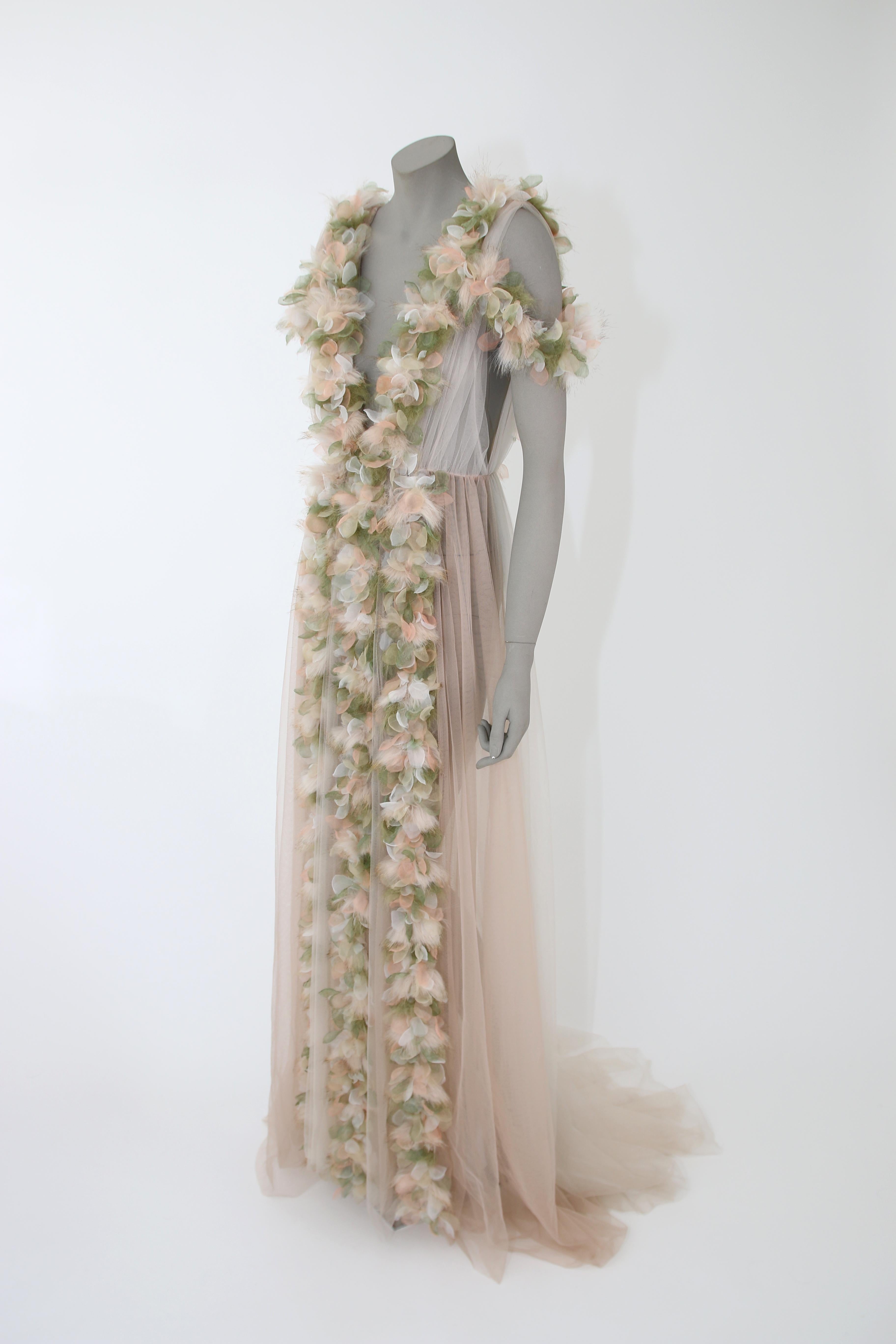 The Angelika Pelush champagne tulle dress gown with tridimensional flowers and faux feathers is a one of a kind exclusive piece. Adorned with romantic botanical tulle leaves in soft peach and green, this etherial dress is detailed with tiny inlay