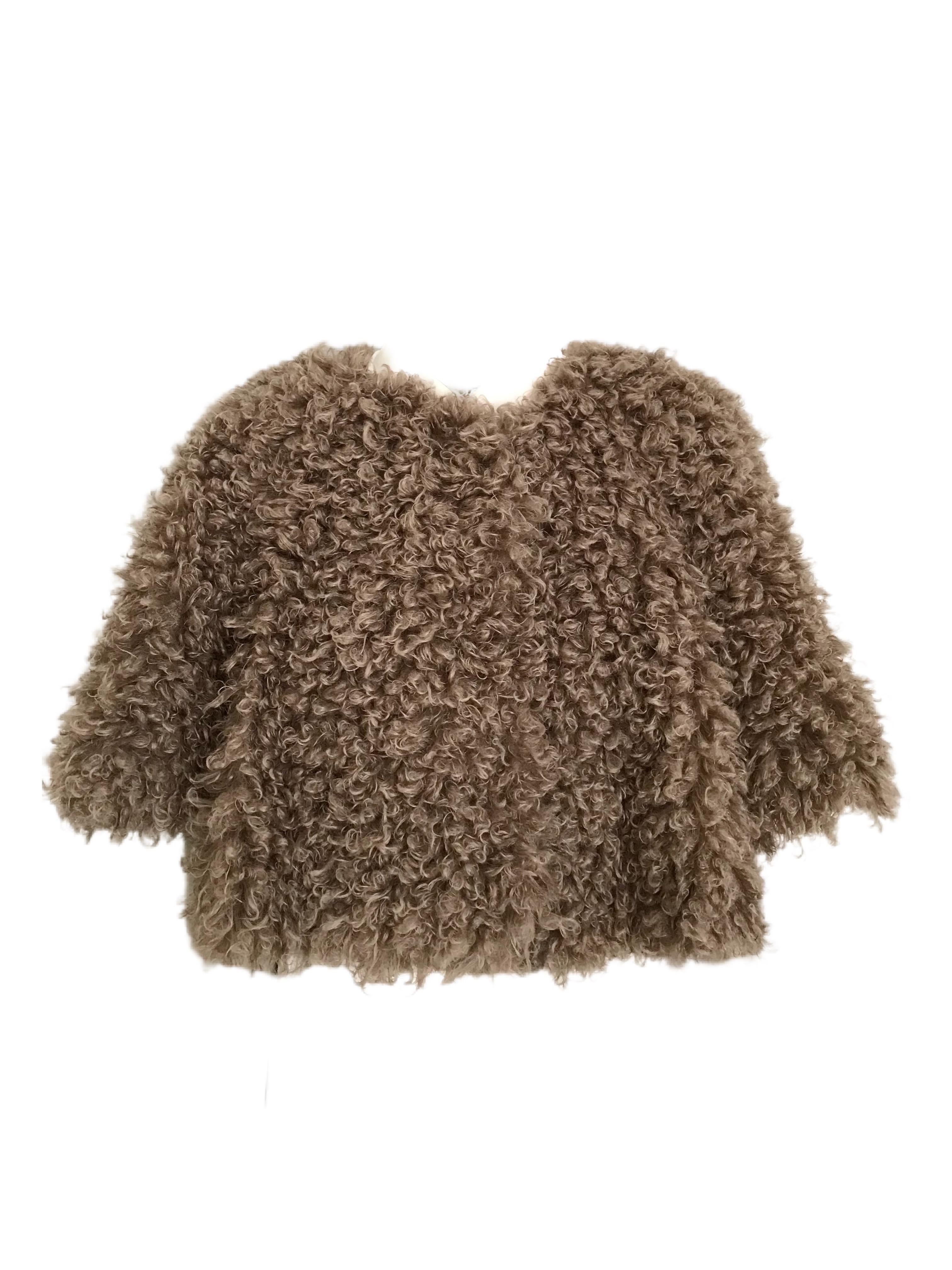 The Pelush faux fur curly reversible jacket is a one of a kind exclusive piece. Two jackets in one. Featuring a rich Italian silk charmeuse abstract print on one side, and a soft curly boucle' faux fur in a soft mushroom color on the opposite side.