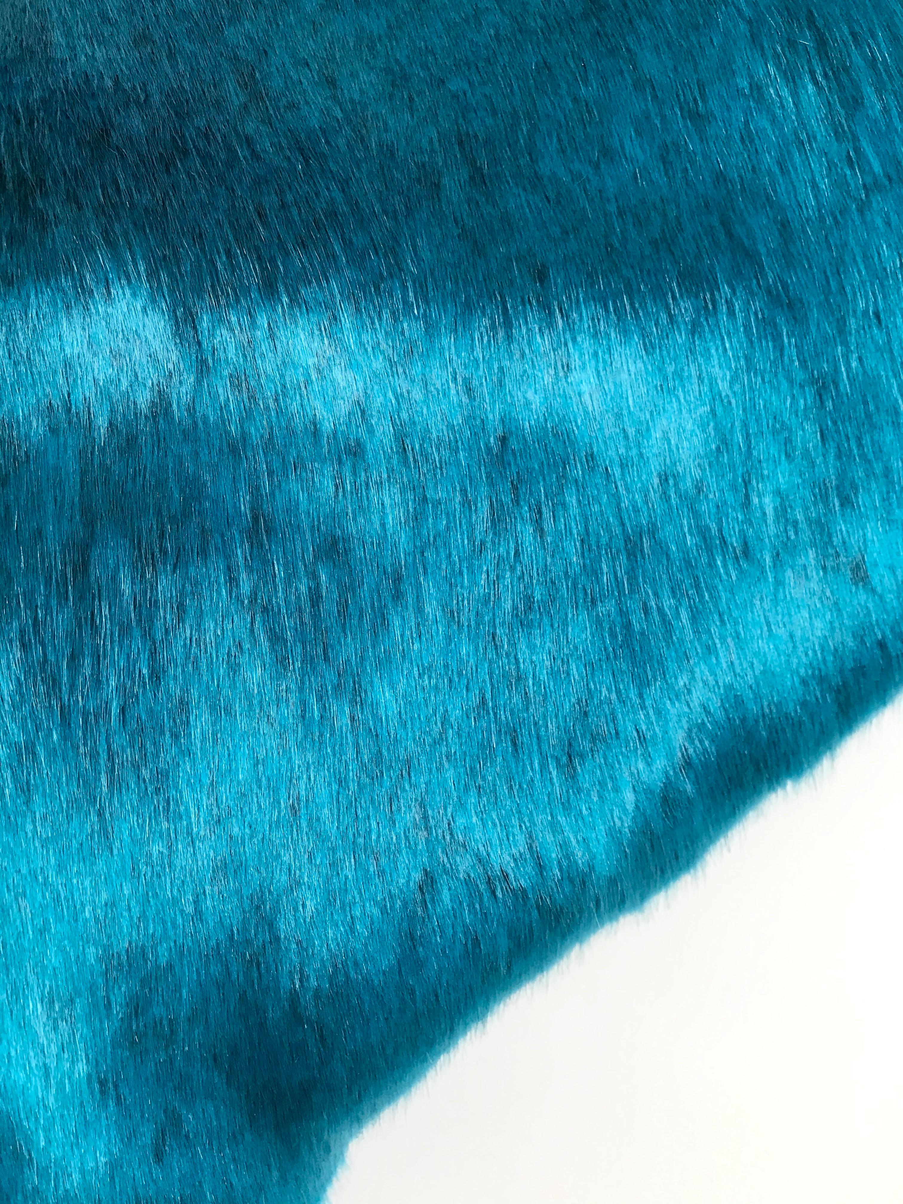 This vibrant Pelush teal faux fur throw blanket is made with the highest quality man made pelage and it's a beautiful replica of the chinchilla fur. Extra soft and plush, the color is custom made for Pelush. The backing has a beautiful Italian tie