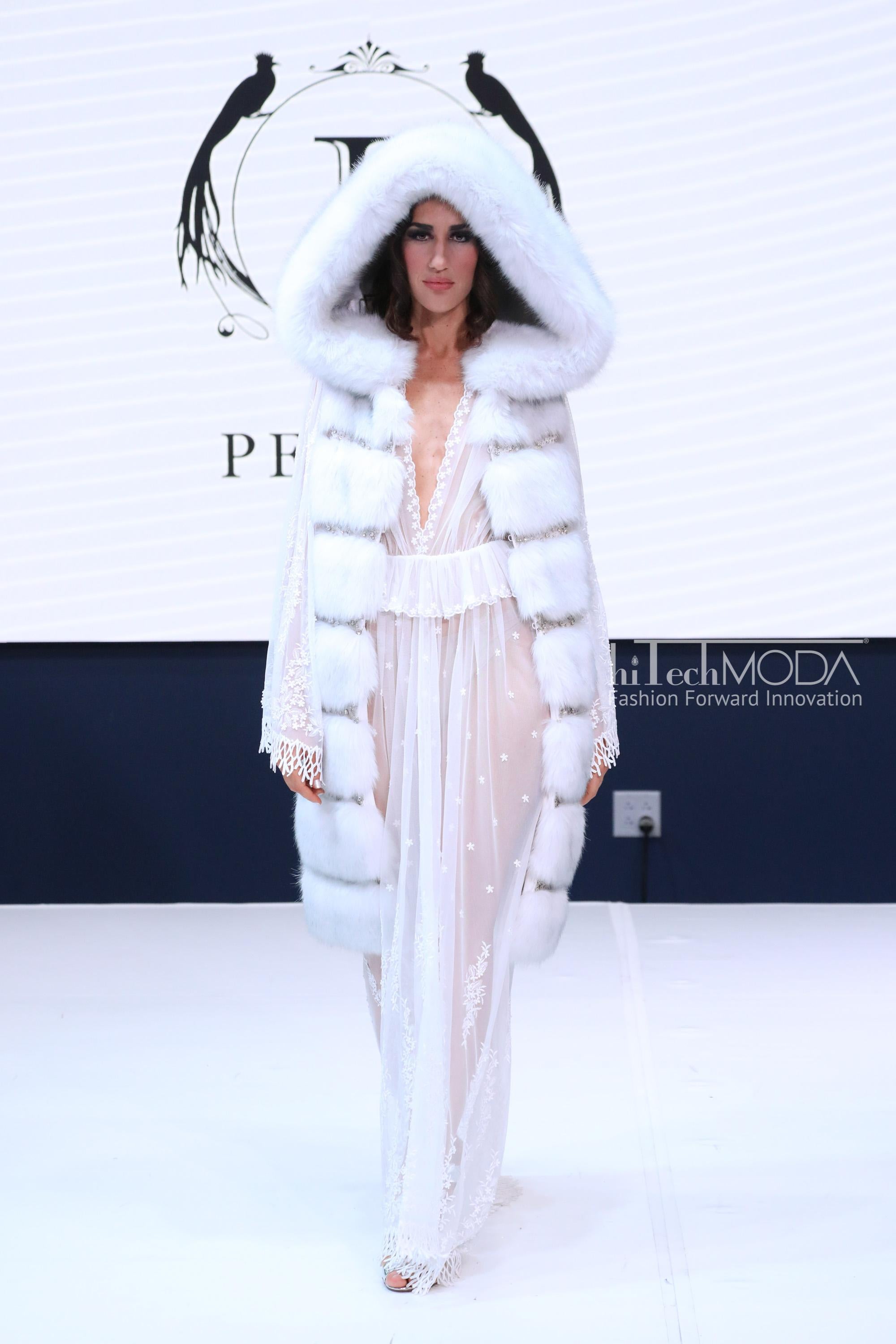 The Soraya Pelush white faux fur vest with crystal embroidery and detachable hood is a one of a kind Couture piece. Featuring the highest quality man made pelage this striking fur free long vest is a magnificent replica of the Arctic fox fur.