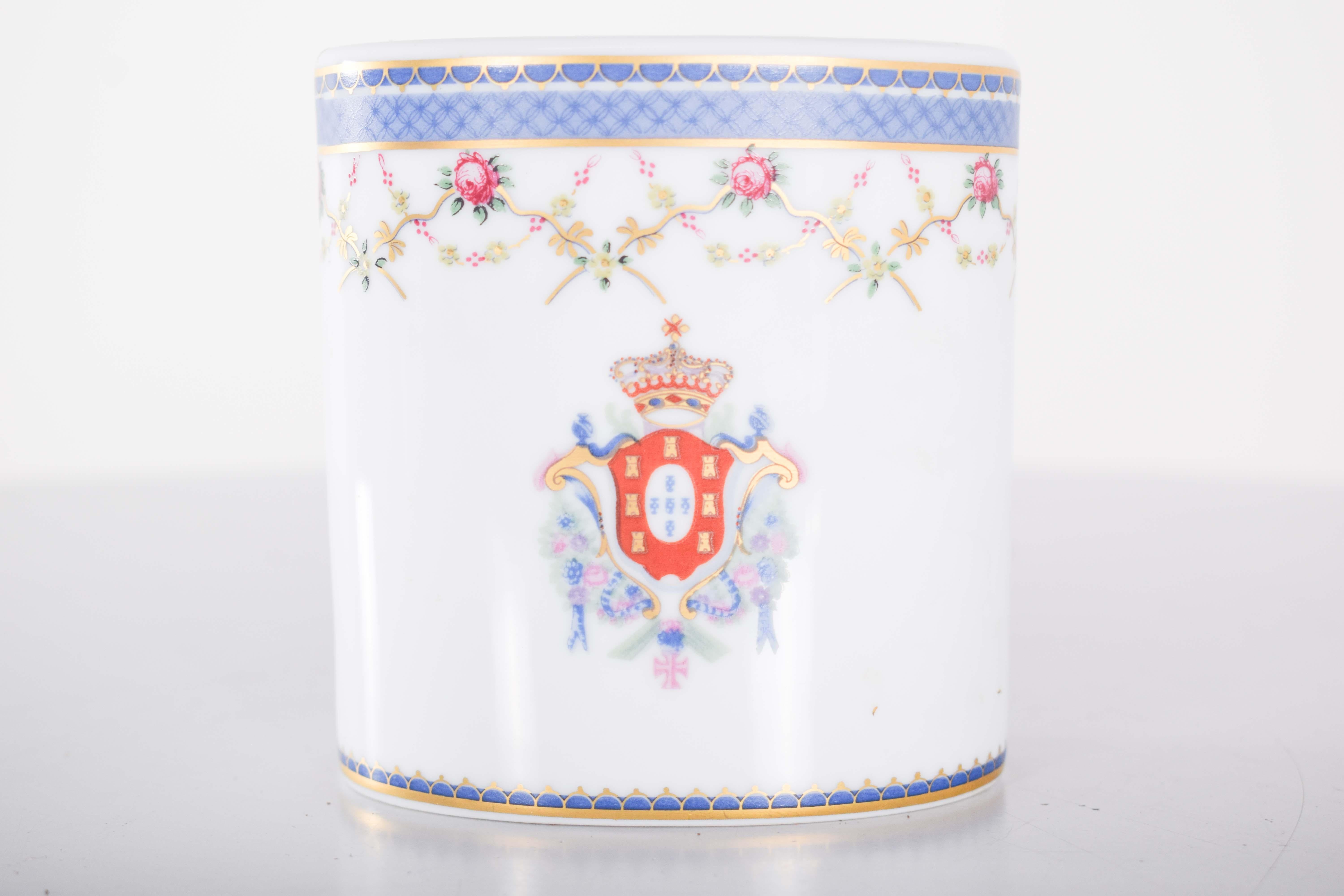 This pen holder is crafted from Aveiro porcelain, featuring a vibrant polychrome decoration. It showcases delicate roses and the distinguished Coat of Arms of Portugal, adding a touch of elegance and national pride. The intricate design reflects the