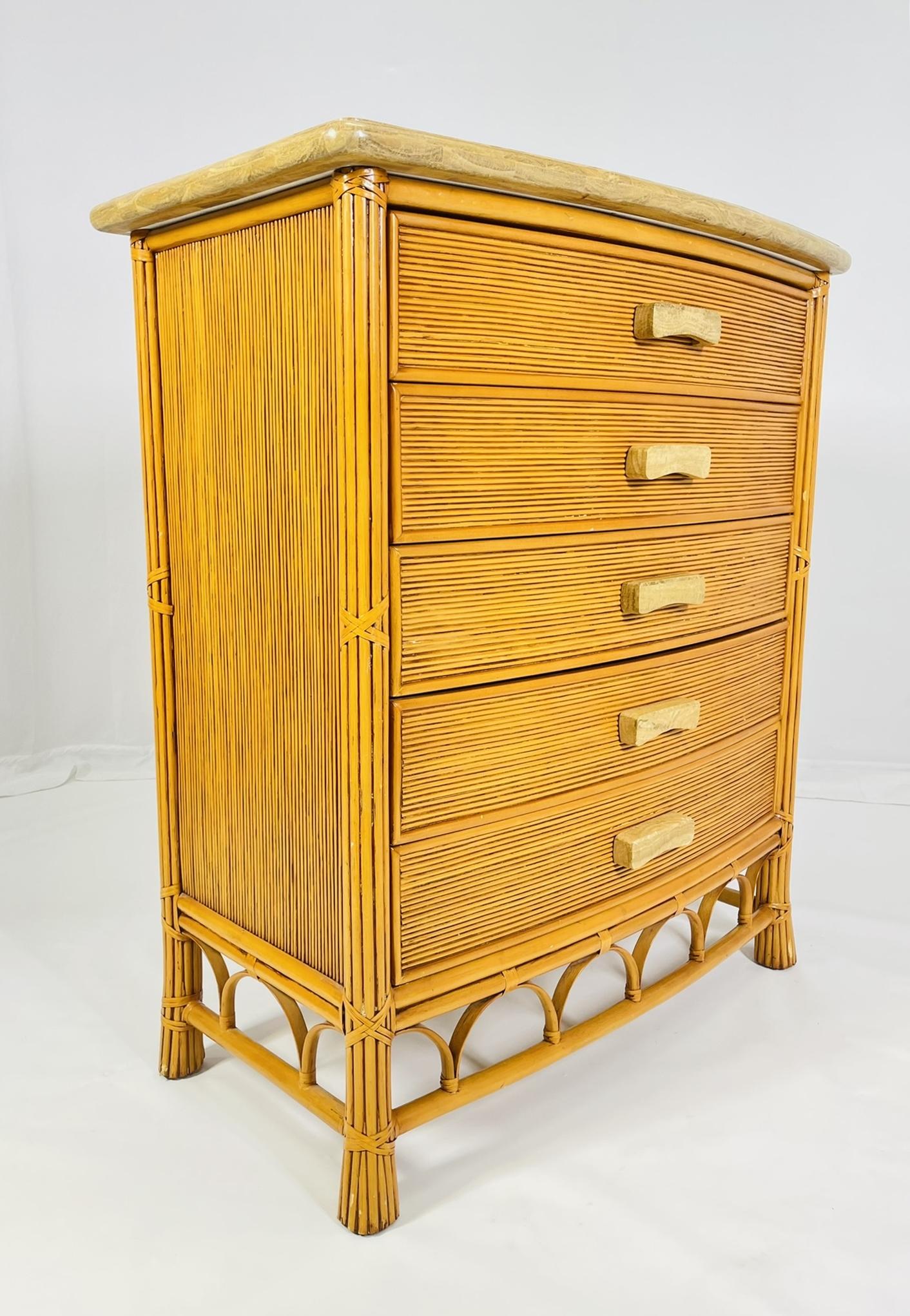 Comò d'epoca a cinque cassetti in canna e rattan progettato e prodotto negli Stati Uniti negli anni '80.
 
Il pezzo è costruito in modo solido, il piano e i tiranti sembrano essere in legno pietrificato o almeno hanno questa sensazione e aspetto.
