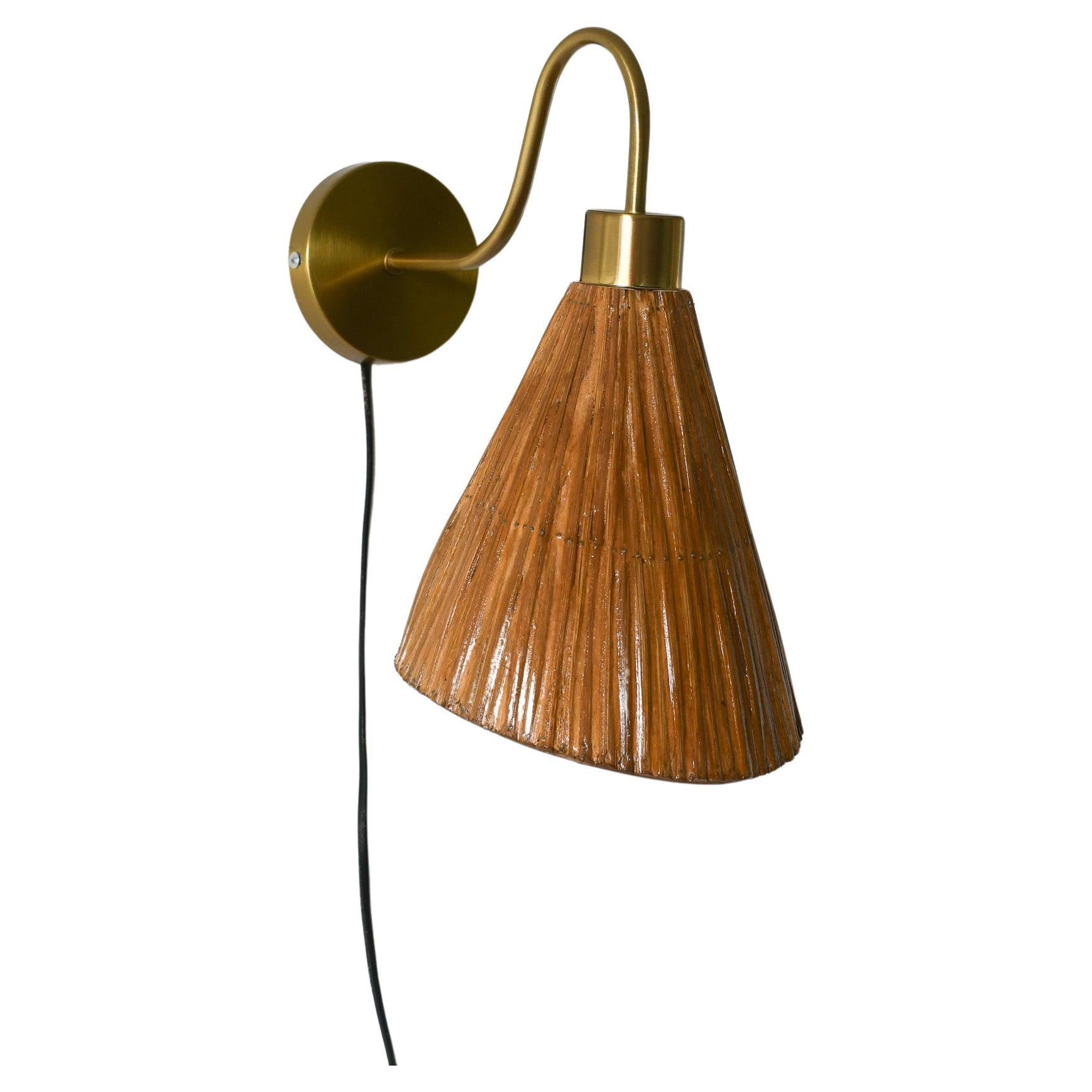 Introduce an elegant and exclusive atmosphere into your space with this handcrafted pencil reed rattan wall sconce lamp. Crafted in a cone shape with luxurious gold accents, this piece exudes sophistication. Enhance your decor with the natural
