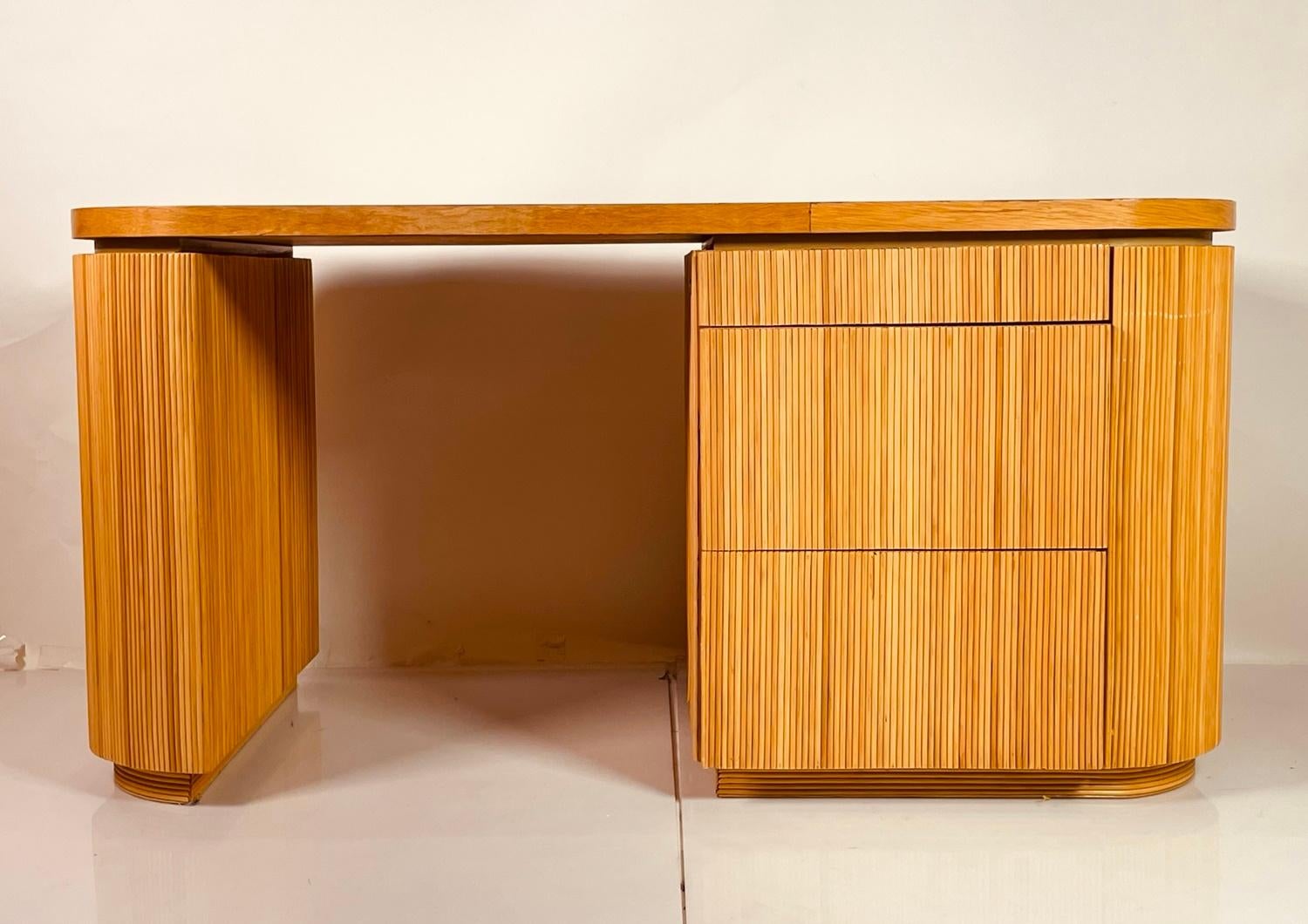 Introducing the Pencil Reed Executive Desk in the Style of Karl Springer, USA 1970's – a timeless piece that exudes sophistication and elegance. This wooden desk boasts a sleek design with clean lines, making it a perfect addition to any modern or