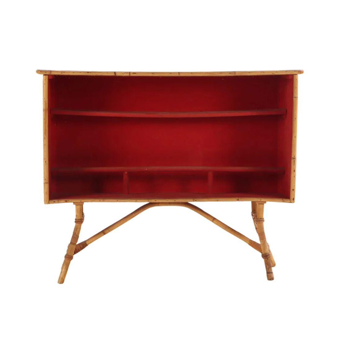 Questo straordinario bar in rattan con canne a matita, realizzato in Francia intorno al 1960, presenta un design unico ed elegante con una splendida forma curva. Il bancone presenta un elegante piano in laminato nero che contrasta elegantemente con