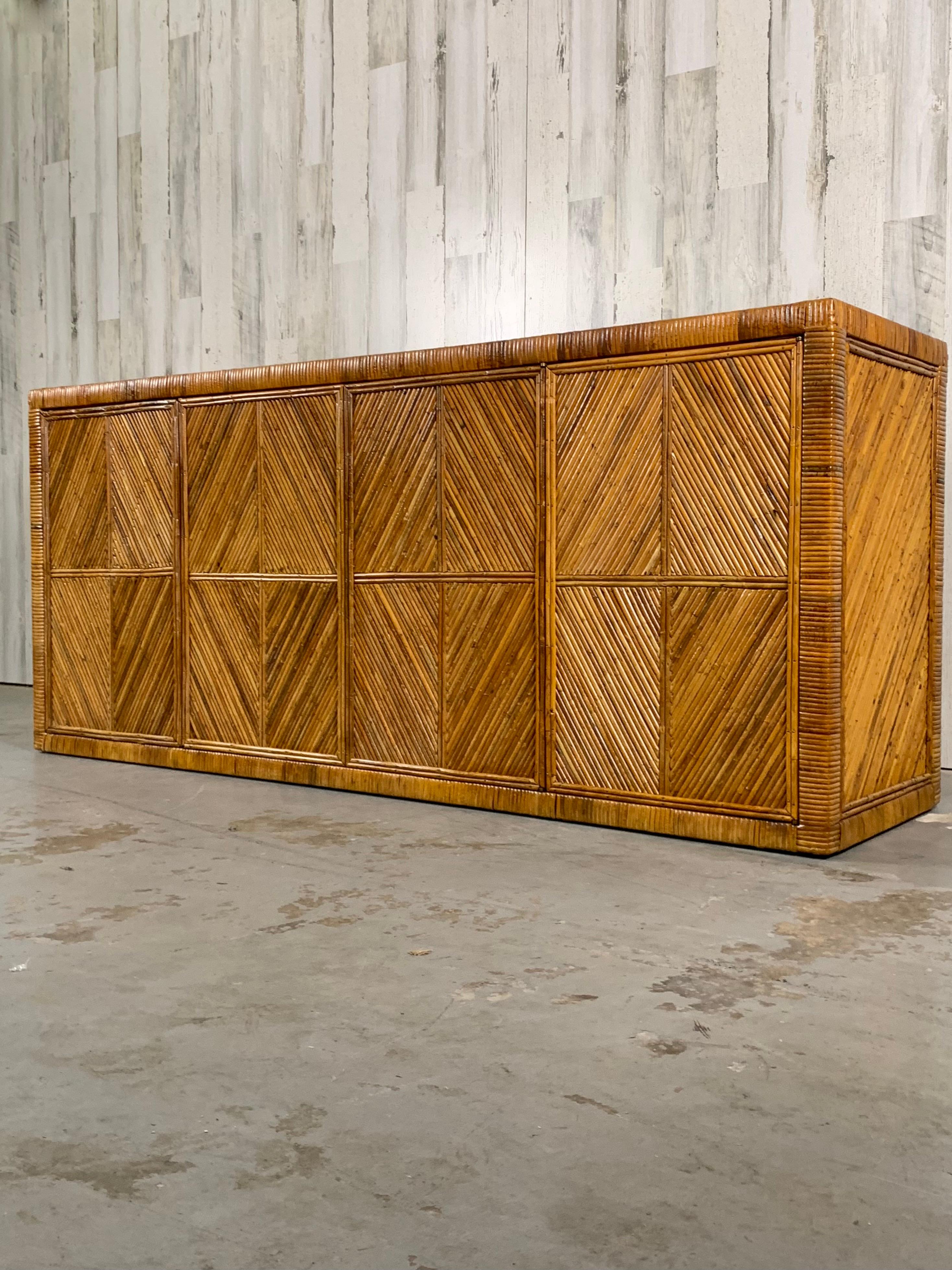 Four door split reed rattan and cane sideboard with glass shelved interior and glass top also finished on the back for room divider option.