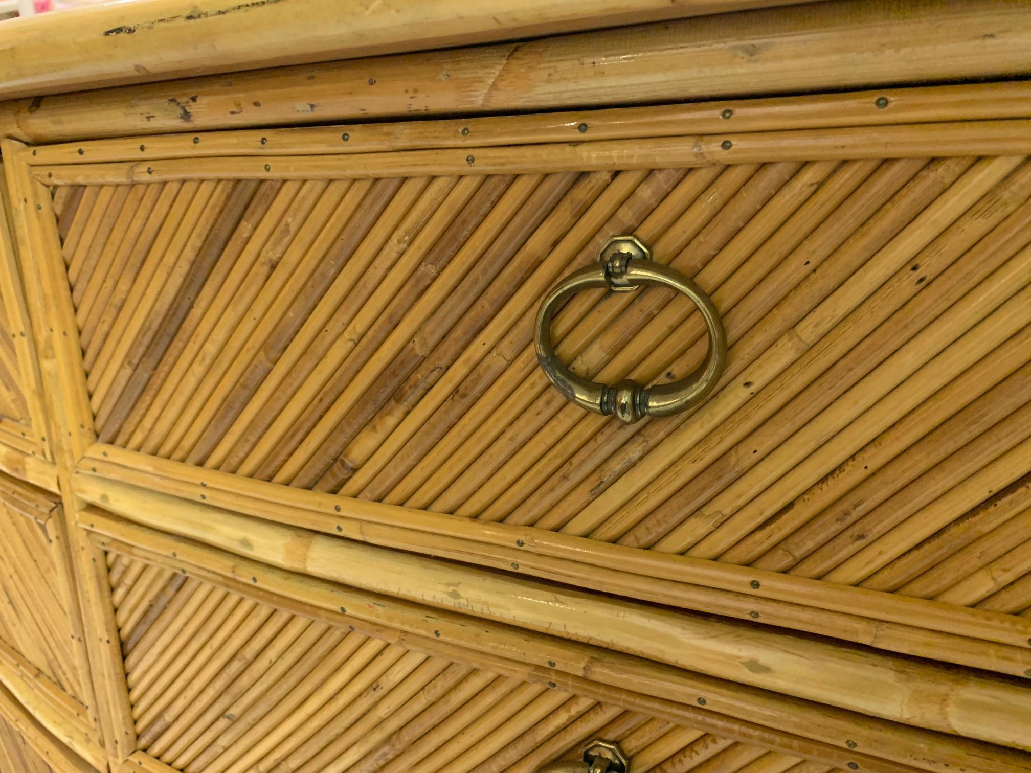 Vintage rattan dresser features full veneer of split reed rattan in geometric pattern. Brass hardware. Bamboo accents. Very good condition with very minor imperfections consistent with age.