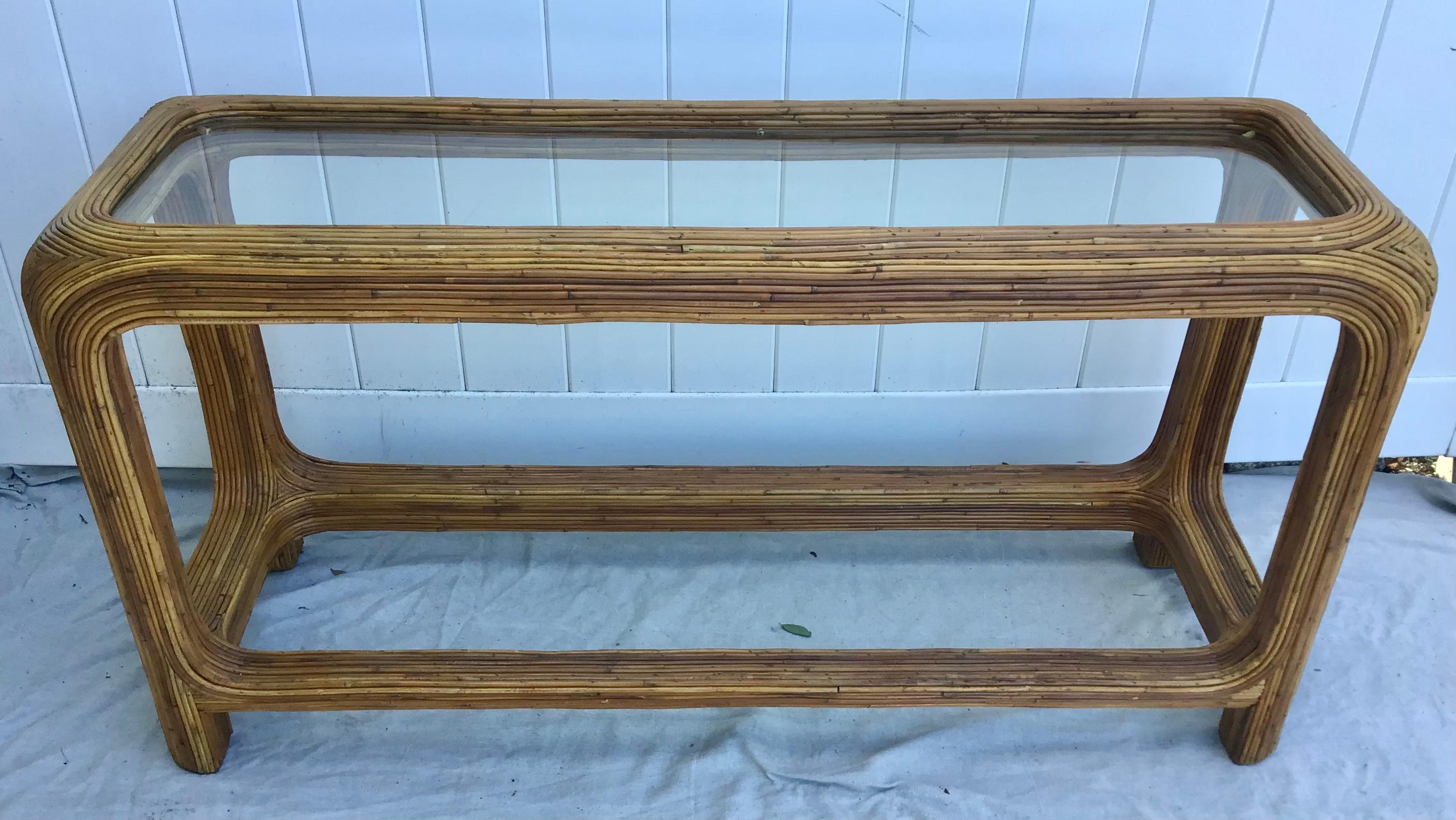 Vintage pencil reed rattan console or sofa table features a full veneer of pencil reed rattan and glass top. These console tables can go in an entrance, against a wall or behind a sofa. Really, anywhere! Clean lines. Great patina.

