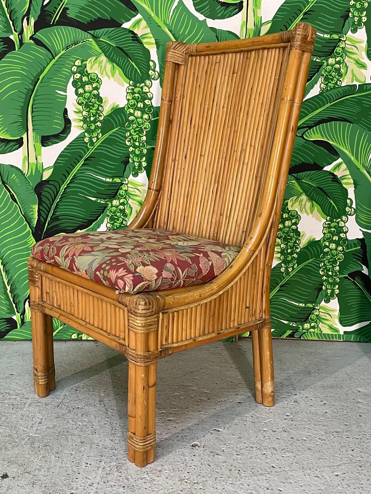 Set of ten vintage rattan dining chairs feature full veneer of split reed rattan and upholstered seats. There are 3 different fabrics among the set, and seats are easily removed for recovering. Frames are very heavy and sturdy. Good condition with