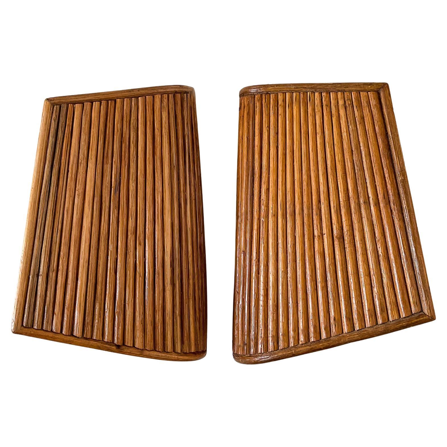 Questa lampada da parete in rattan con canne a matita combina la funzionalità moderna con un design scultoreo in rattan ispirato all'arte italiana di metà secolo. Gli intricati dettagli in rattan offrono una consistenza e un calore unici alla