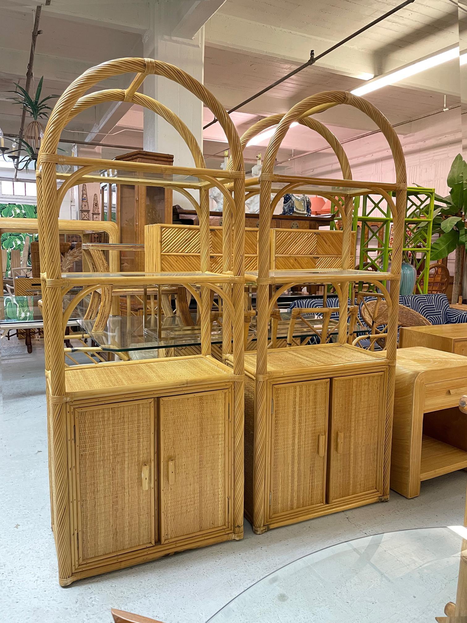 Vintage pair of rattan etageres wrapped in split reed in a twisted pattern. Surfaces veneered in woven cane raffia, with top two shelves in glass. Very good condition with minor imperfections consistent with age (see photos).
Shipping to most of