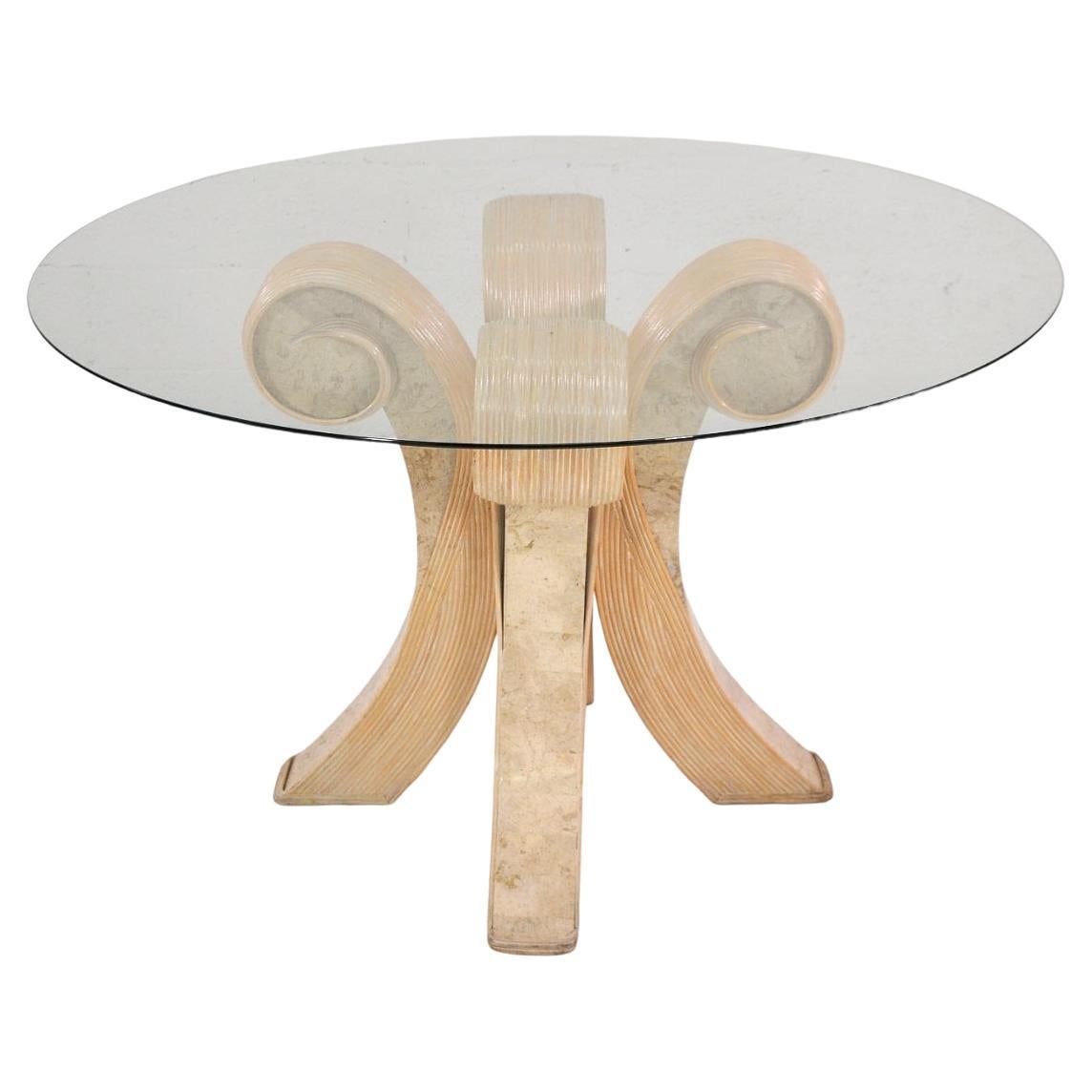 Vintage bentwood pencil reed and travertine dining table in the style of Betty Cobonpue, from the 1980s. The table features a round glass top and a pedestal base with wonderfully sculpted split reed foliate designs and tessellated beige Italian