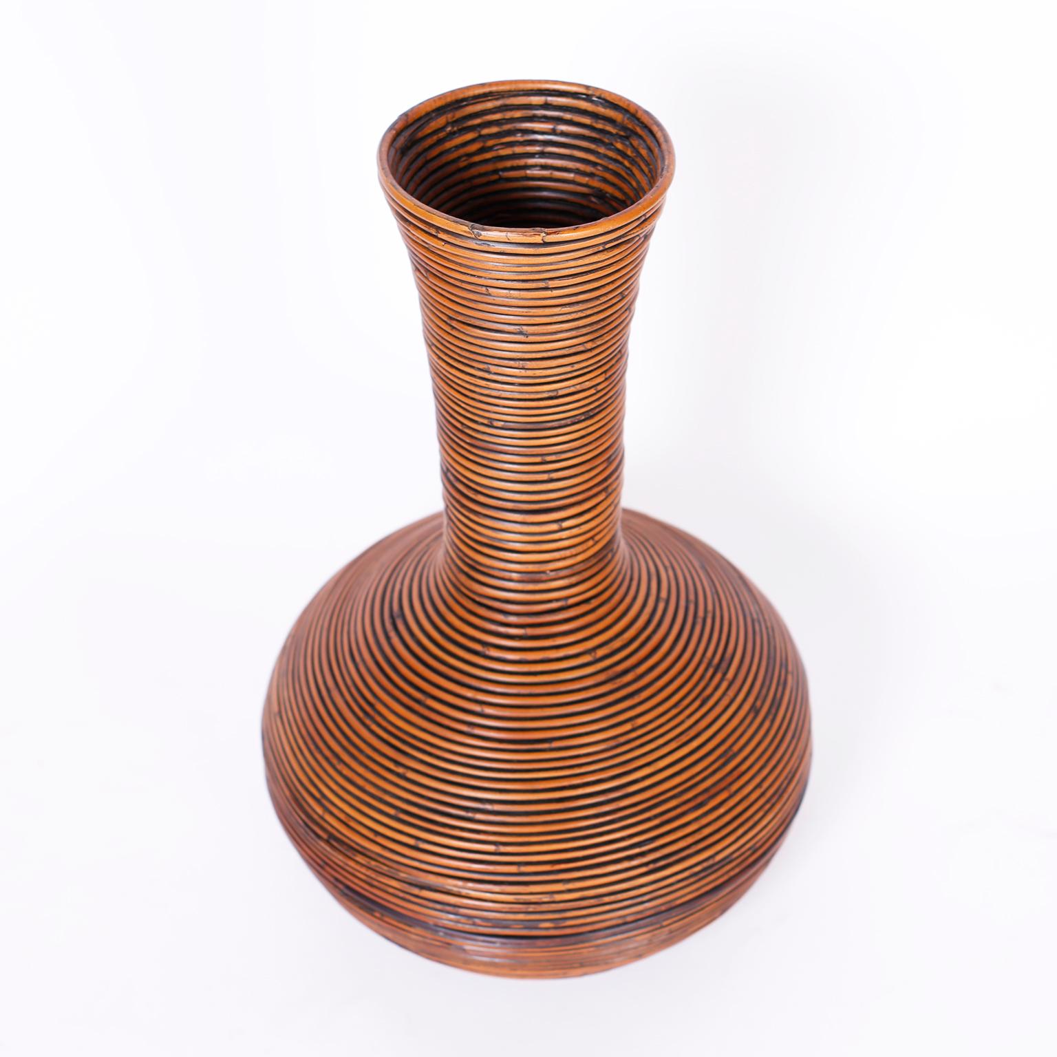 Mid century faux vase crafted with pencil reed in an ingenious bending technique in a classic modern form.