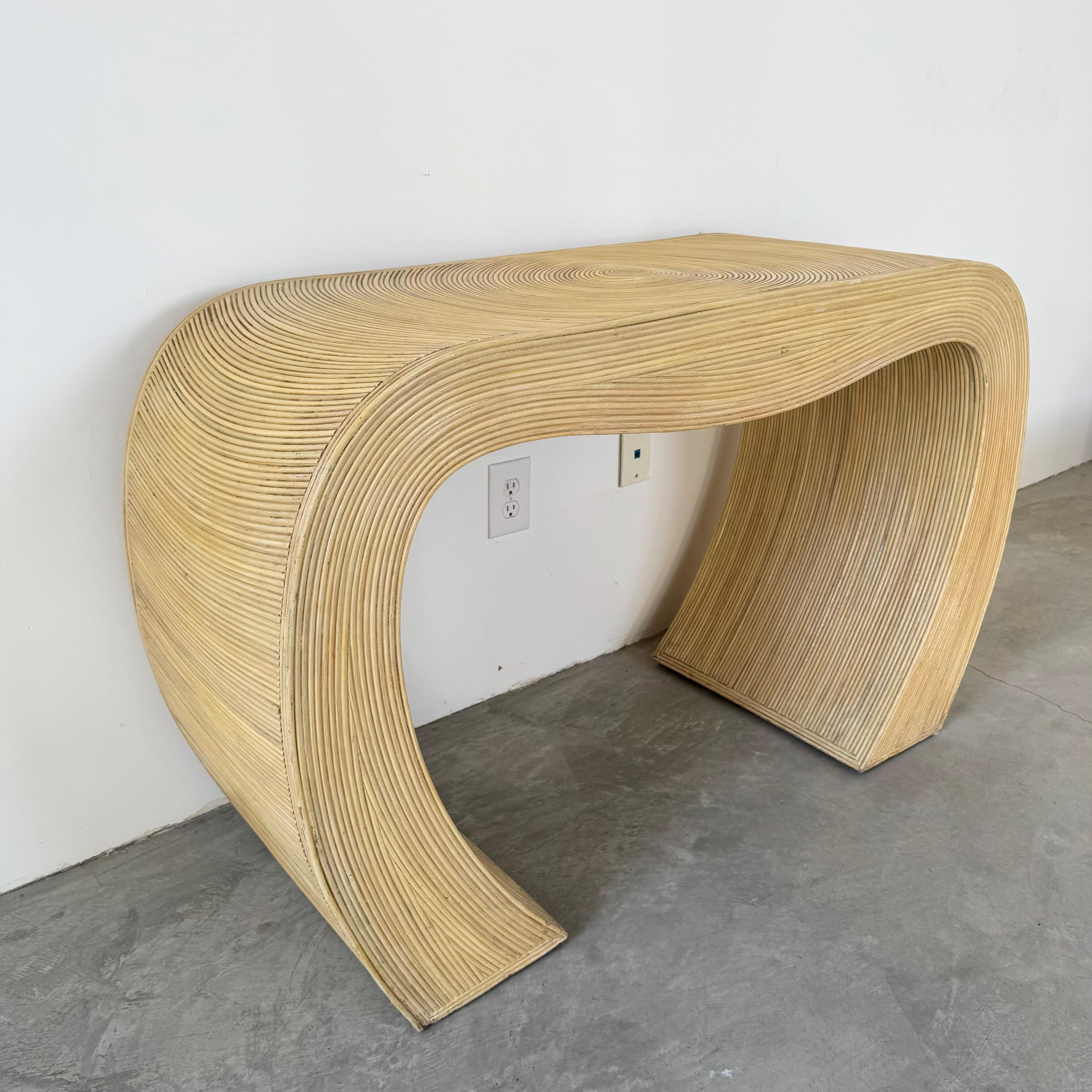 Midcentury design with a bohemian flare, this piece will transport you to a breezy summer day. A gorgeous pencil reed waterfall console with great lines and curves. Organic rounded edges give this piece a tranquil, eclectic personality. Sand-colored
