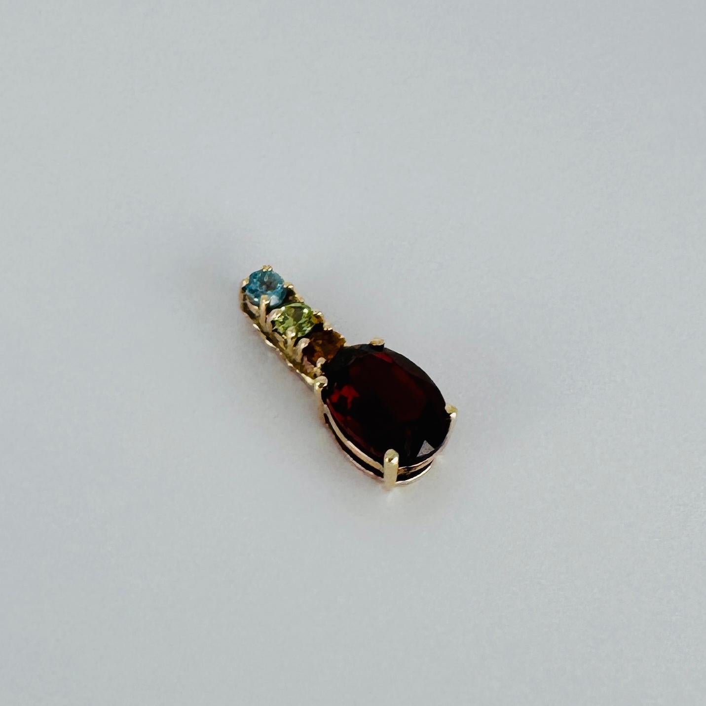 This beautiful vintage pendant is crafted from 14 carat yellow gold and features 4 beautiful gemstones, an oval facetted garnet and a special 3-some. Experience how colorful these gems will complete your look. Must-have for every jewelry lover.
