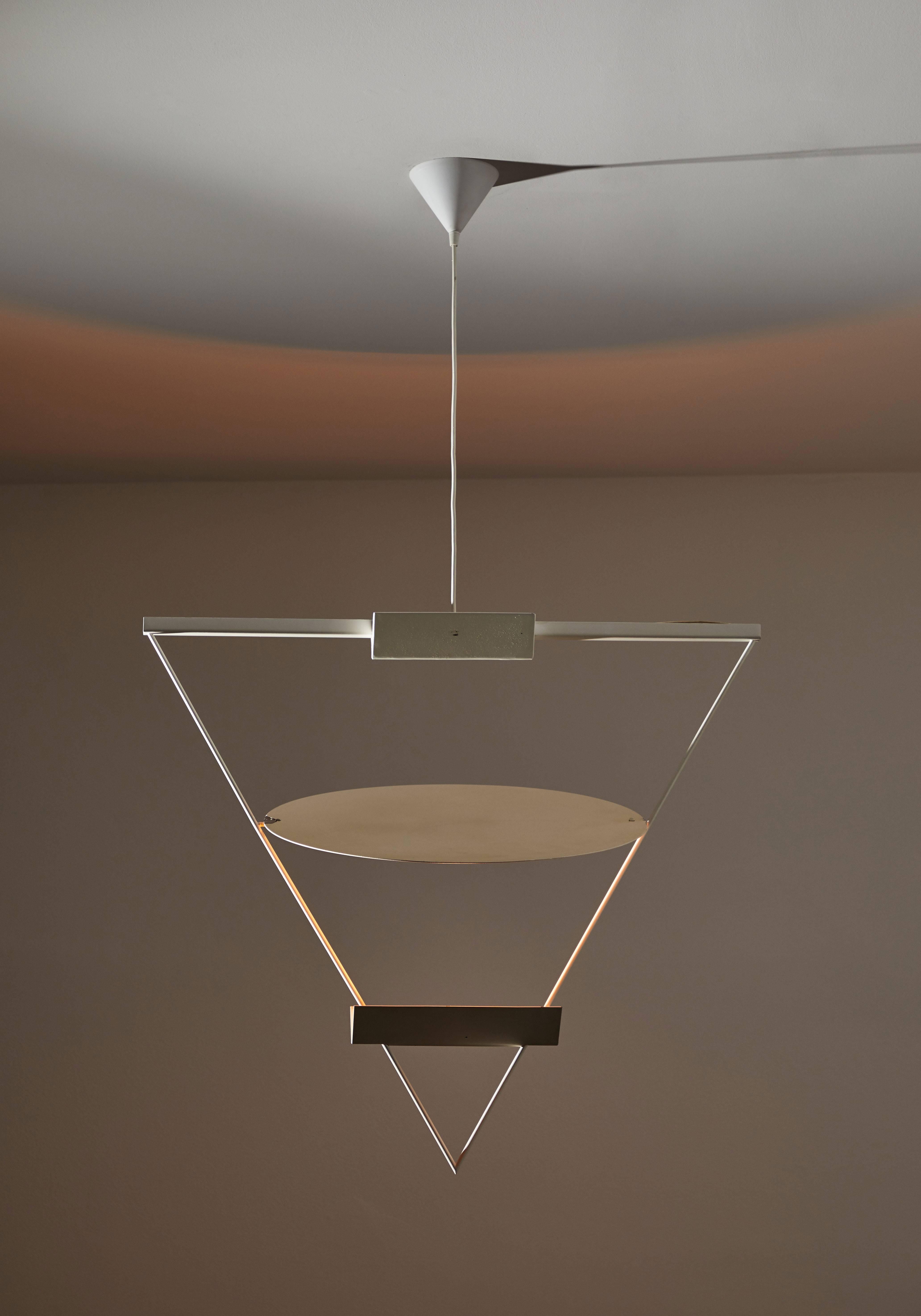 Triangular pendant by Mario Botta for Artemide. Designed and manufactured in Italy, circa 1980s. Enameled metal triangular shaped structure which houses a singular halogen bulb. Circular panel can be adjusted to reflect light in various directions.