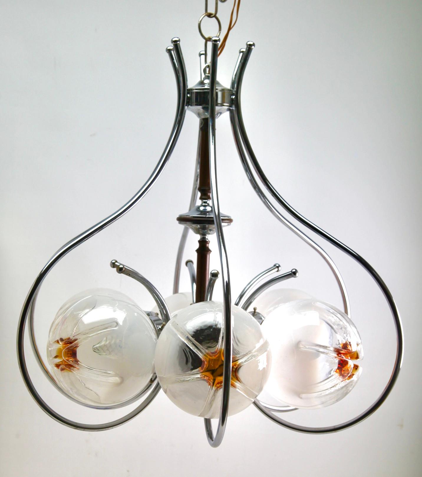 Pendentif avec un globe en verre transparent avec des inclusions orange, Italie, 1970 par Mazzega.
Jetant une belle lumière ondulée sur un mur et un plafond.

La lampe fonctionne partout dans le monde

Récemment nettoyé et poli afin qu'il soit
