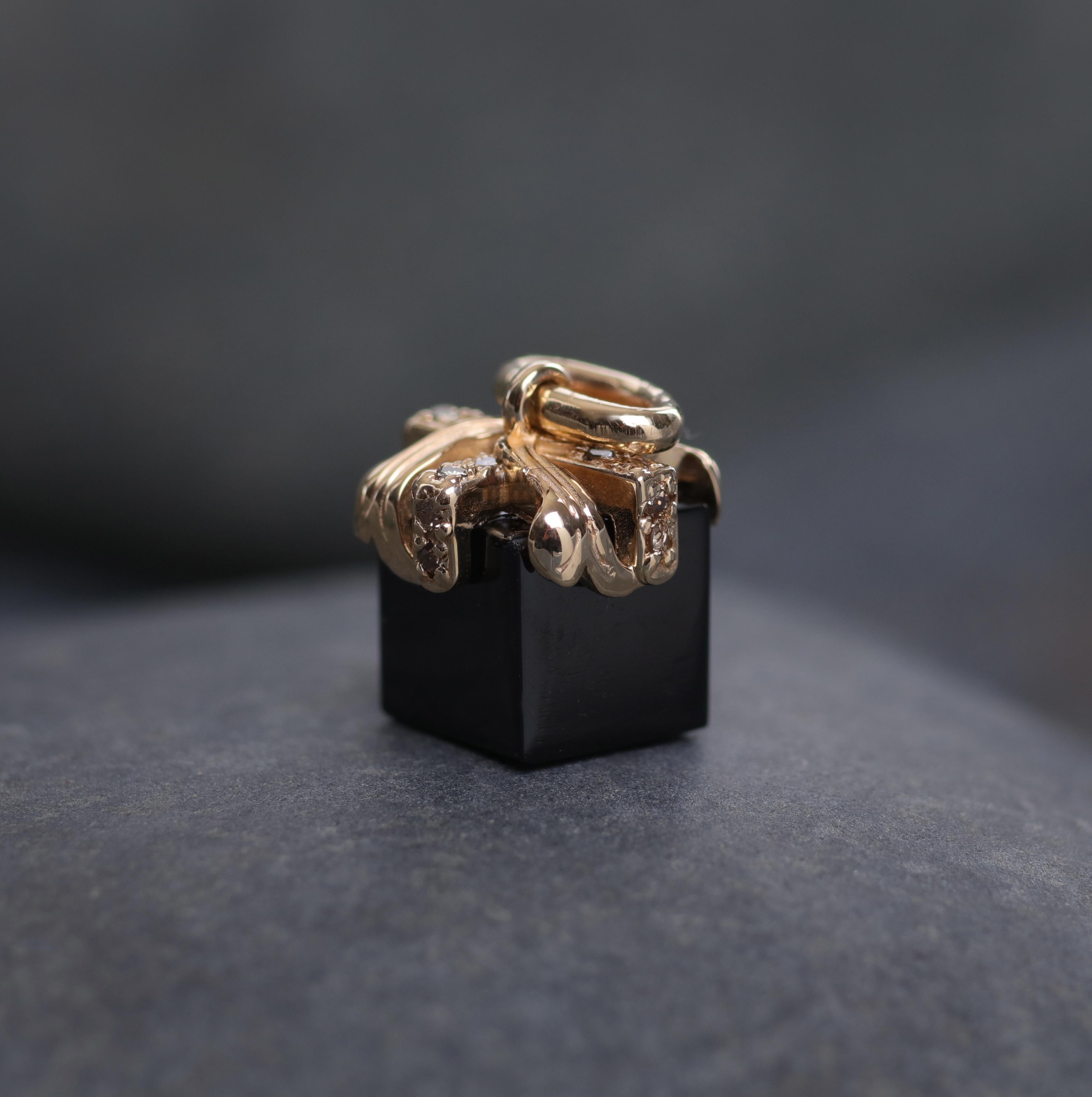 A yellow gold, Champagne diamonds, and black spinel charm that whispers: 