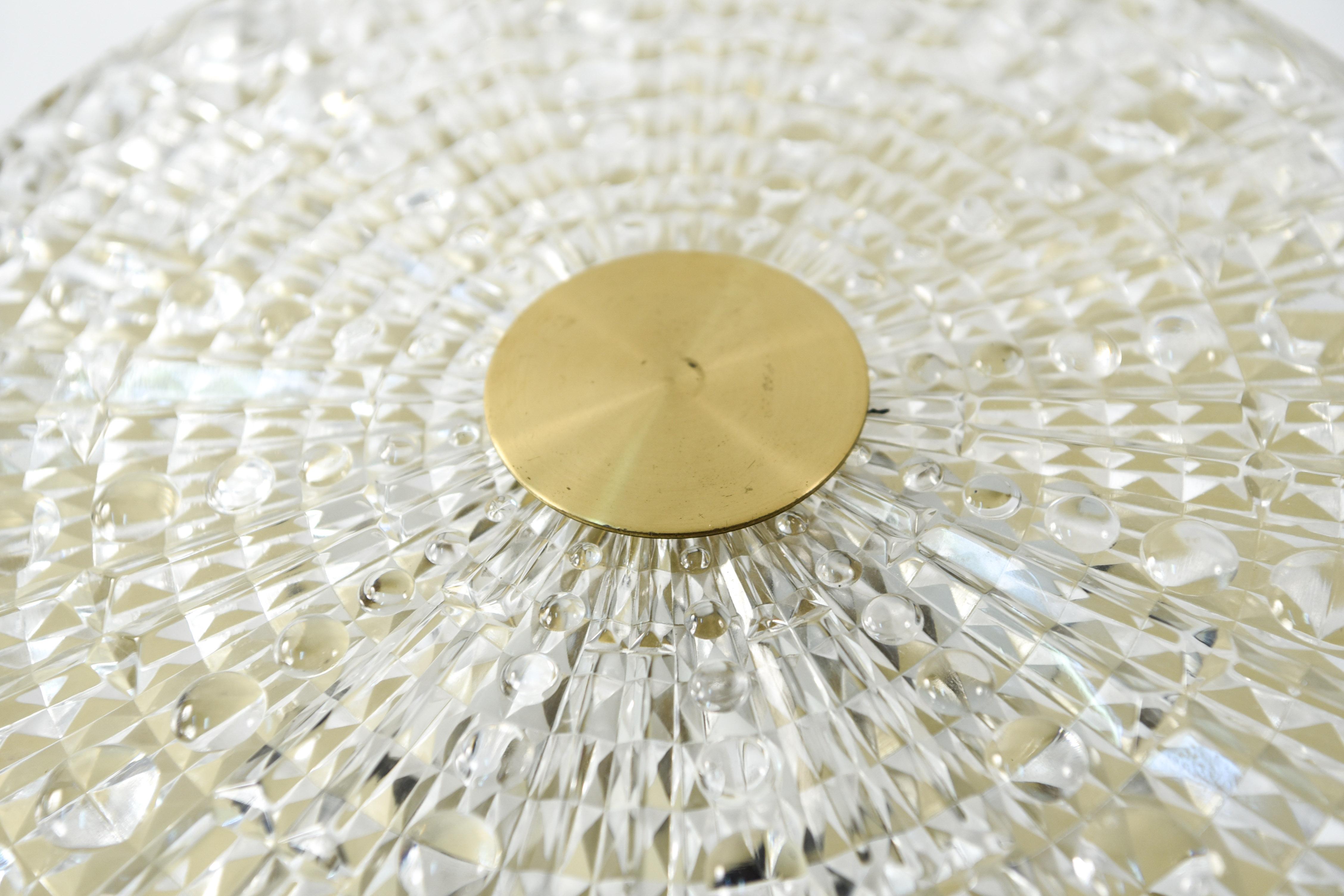 This Swedish midcentury pendant chandelier was designed by Carl Fagerlund and produced by Orrefors in the 1960s. This piece features a textured crystal body with brass hardware and is of a Classic form characteristic of Fagerlund's collaborations