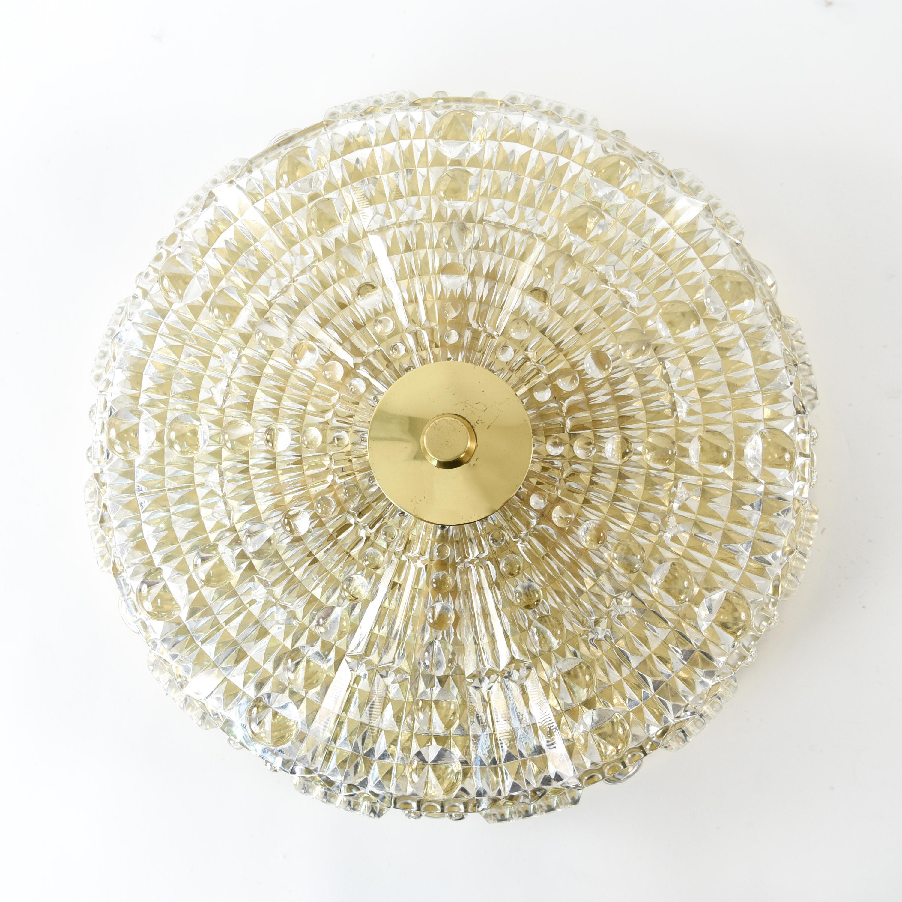 This Swedish midcentury pendant chandelier was designed by Carl Fagerlund and produced by Orrefors in the 1960s. This piece features a textured crystal body with brass hardware and is of a classic form characteristic of Fagerlund's collaborations