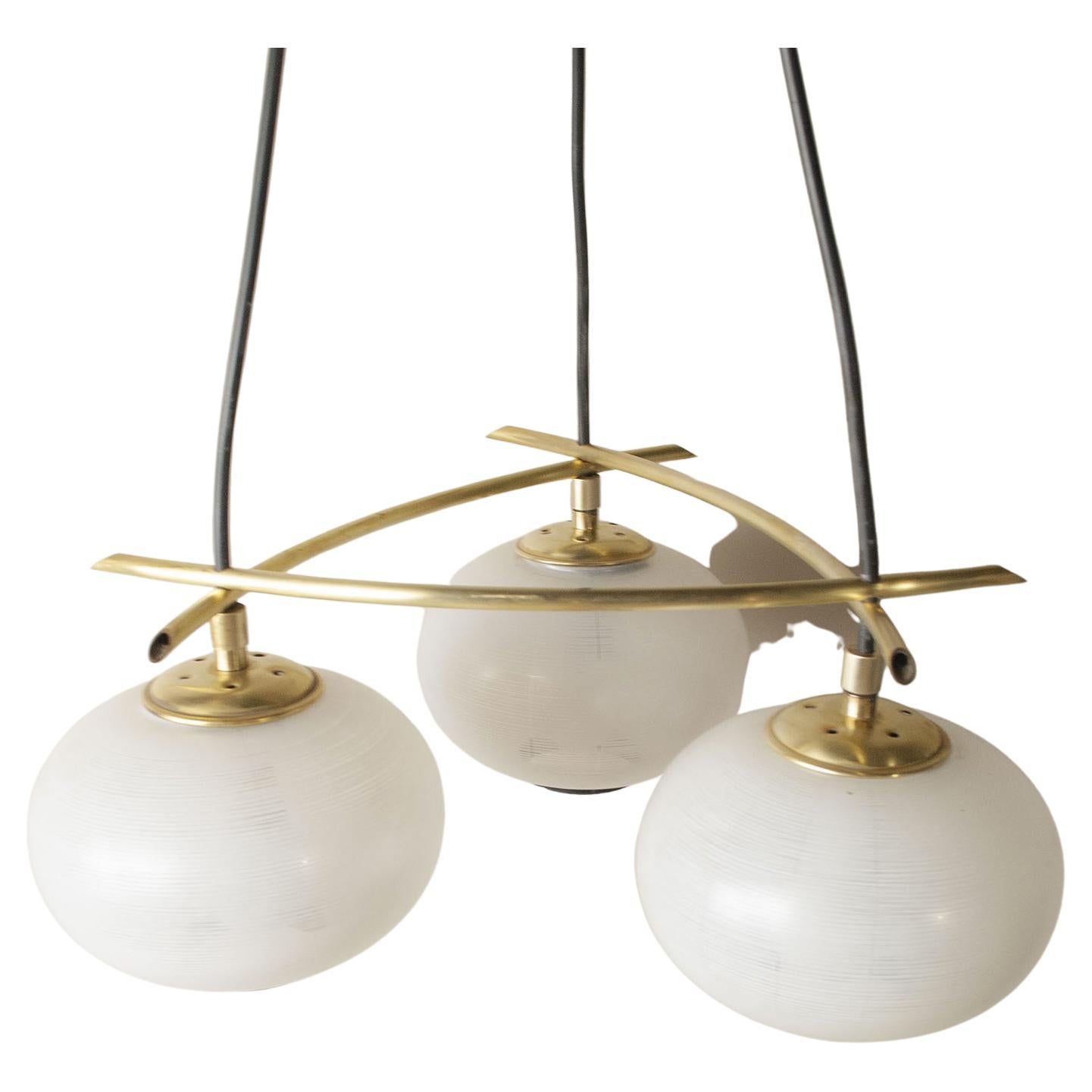 Pendant chandelier composed of three illuminating parts with frosted glass spheres brass structure Italian production 1950s.