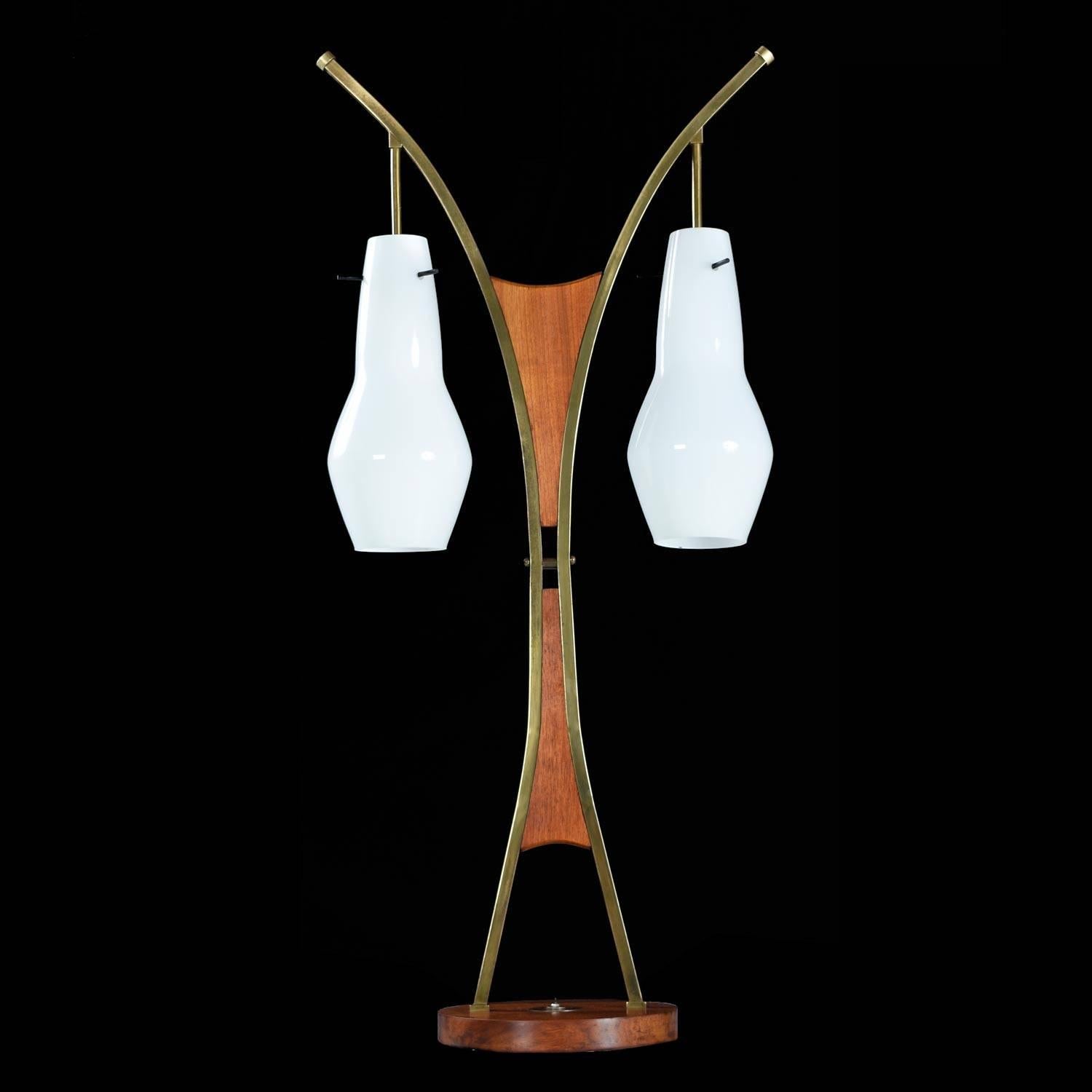 We've never seen this lamp before and had no luck deciphering its maker. None the less, it has a designer look and an sleek combination of elements. The glass shades suspend with a subtle architectural elegance against the walnut and brass backdrop.