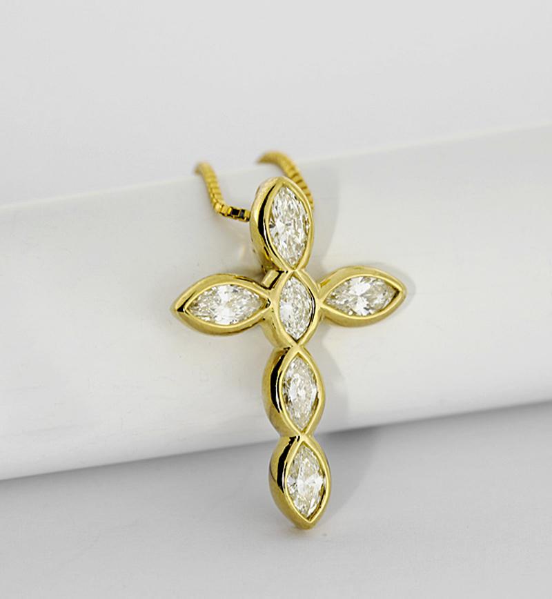 An exquisitely crafted pendant presenting itself in the form of a cross adorned with six resplendent diamonds in navette-cut., total weight of approximately 1.28 carats. The open backed designs allows  the diamonds to radiate their full