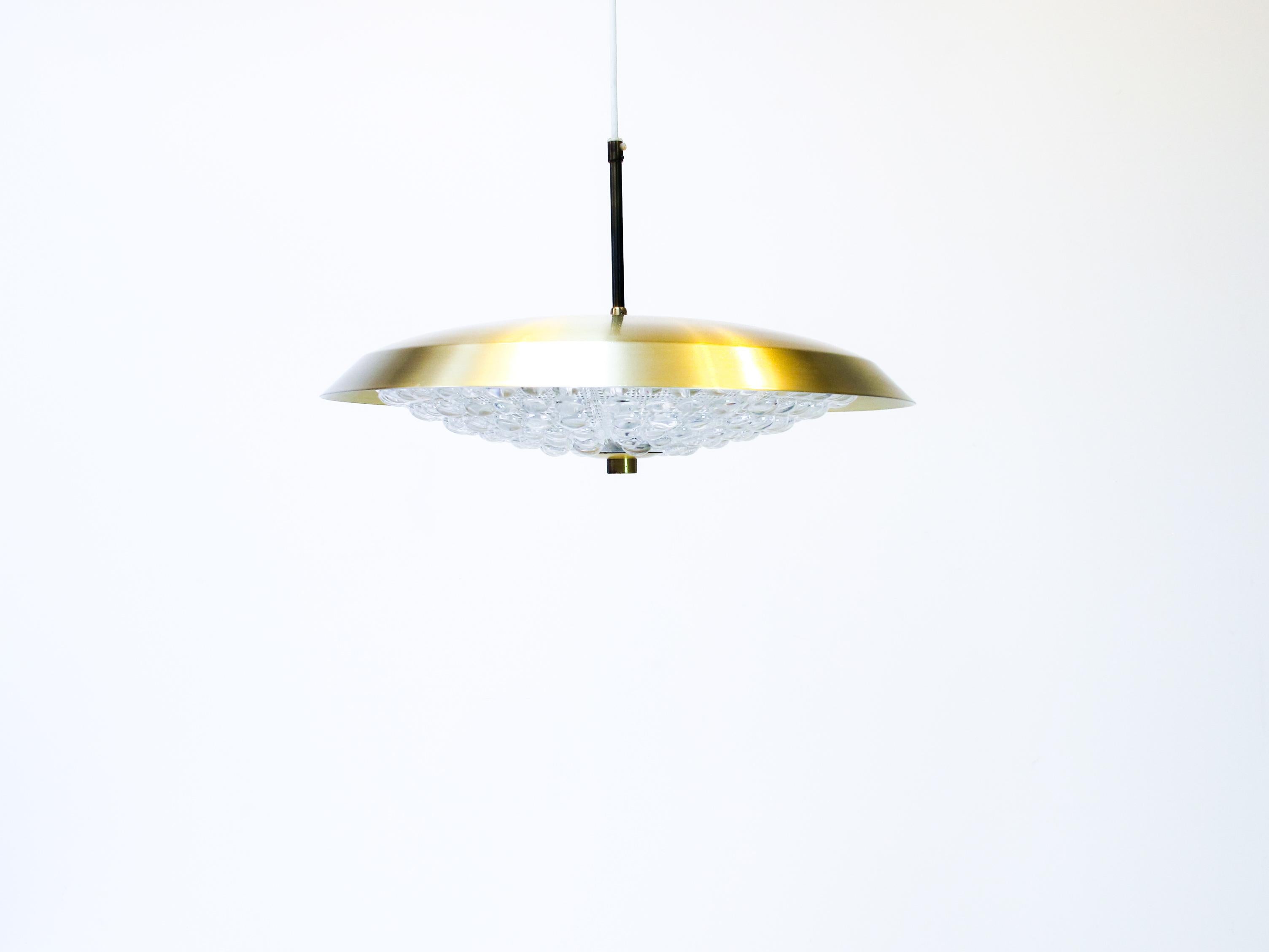 Pendant light designed by Carl Fagerlund.
This saucer top of the pendant are made of brass.