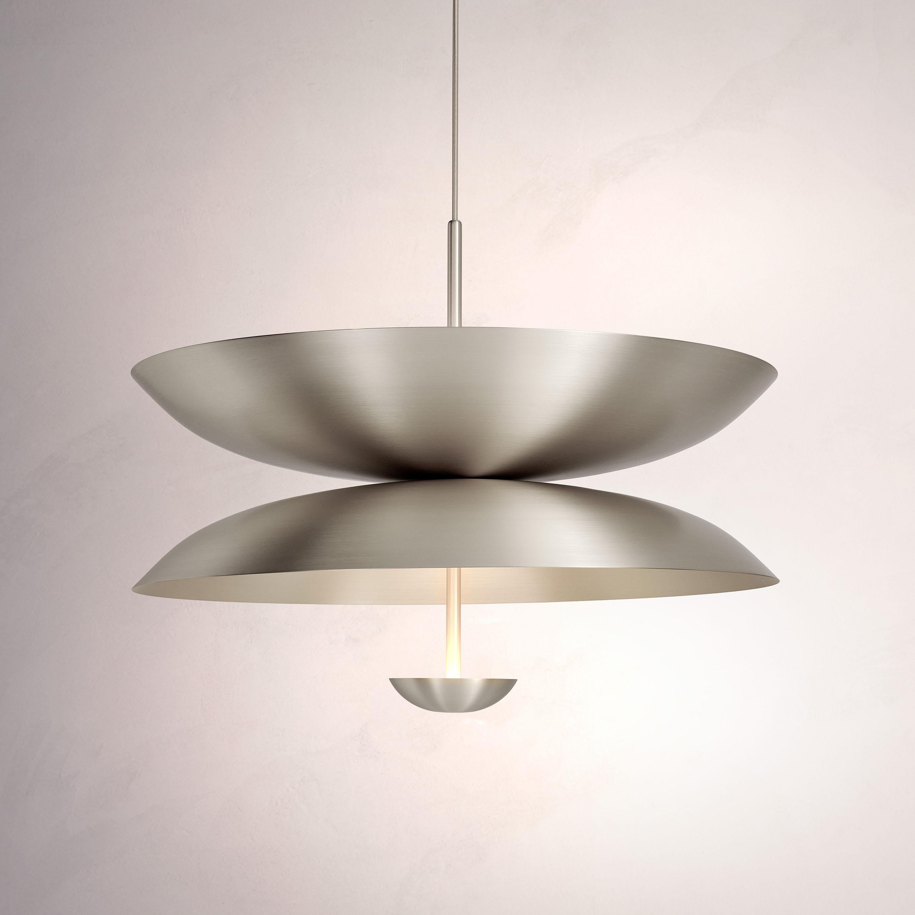 Inspired by planet-like shapes and textures, the Cosmic collection plays with both metal properties and a selection of patina finishes.
 
The Pendant Duo Seleno is composed of three carefully hand-spun steel plates and preserves the beautiful