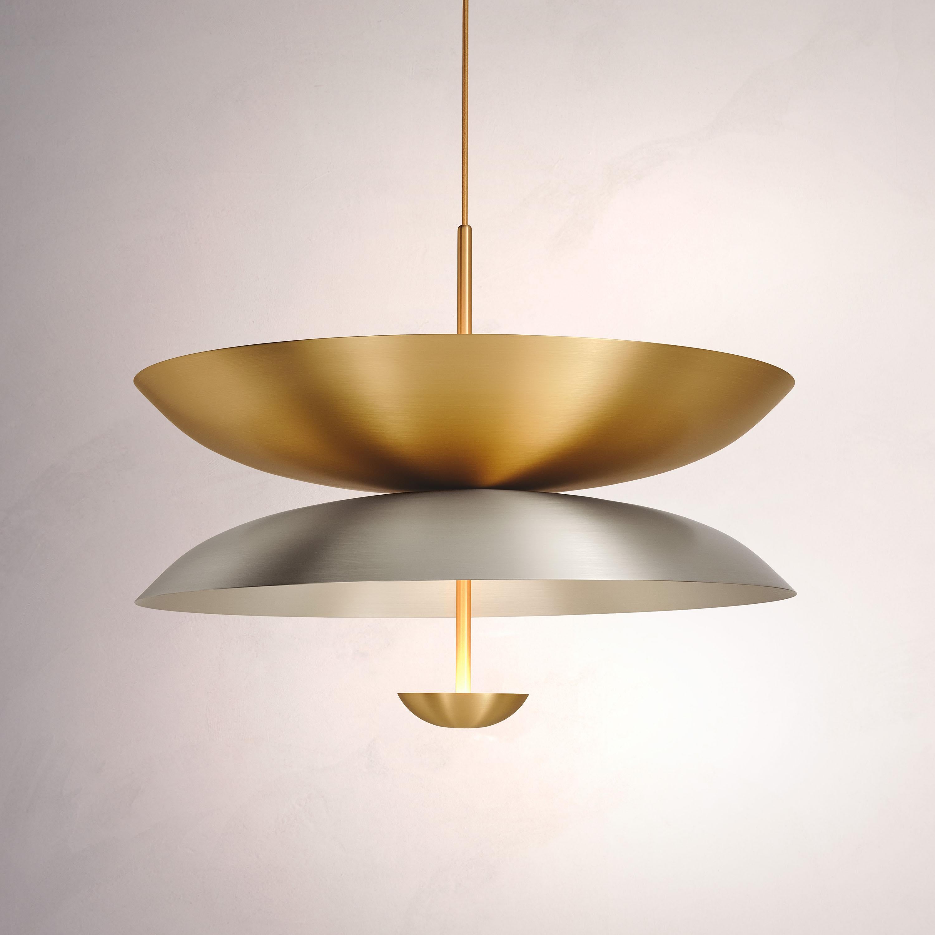Inspired by planet-like shapes and textures, the Cosmic collection plays with both metal properties and a selection of patina finishes.
 
The Pendant Duo Seleno Sol is composed of three carefully hand-spun steel and brass plates and preserves the