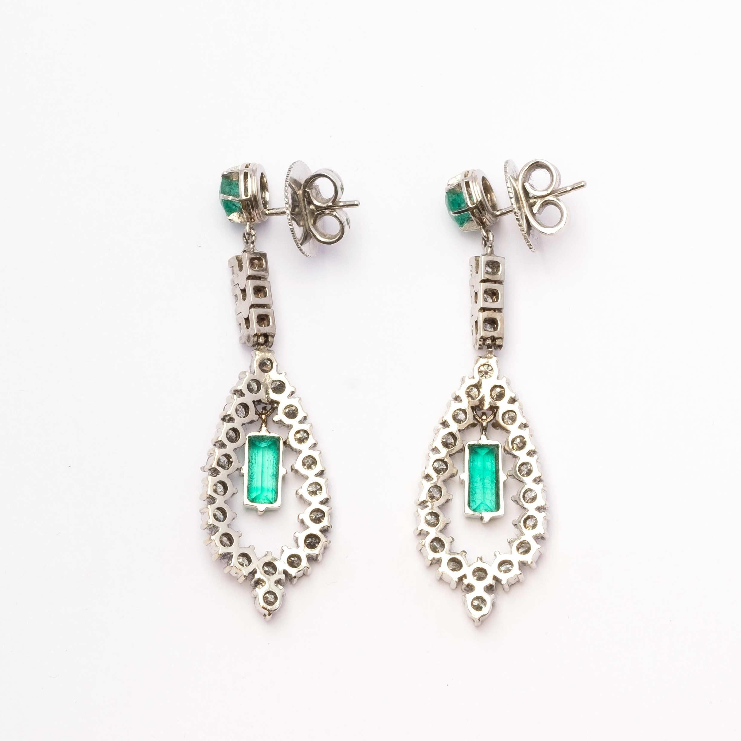 1960s period earrings set in 18ct white gold with round cut diamonds and natural emeralds. The emerald at the centre of the drop is mobile which gives extra movement and light to this beautiful earring.

Highlights:
- 1960s period
- 18ct white