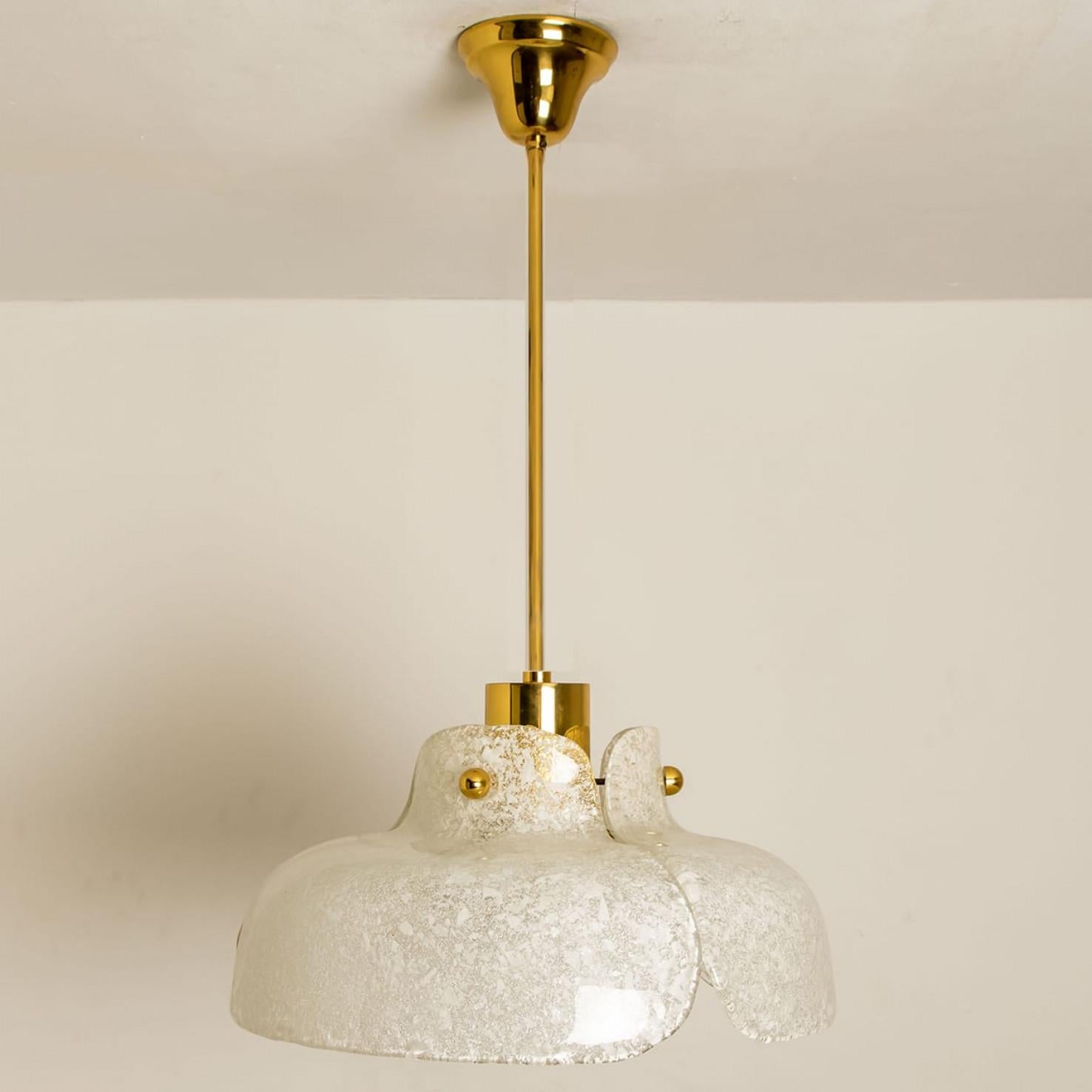 Beautiful pendant lamp in the shape of a flower. In the style of Kalmar.
Three leaf-like pieces of thick speckled glass are wrapped around a glossy brass base.
The light shining trough the glass gives special effect.

In excellent vintage condition.
