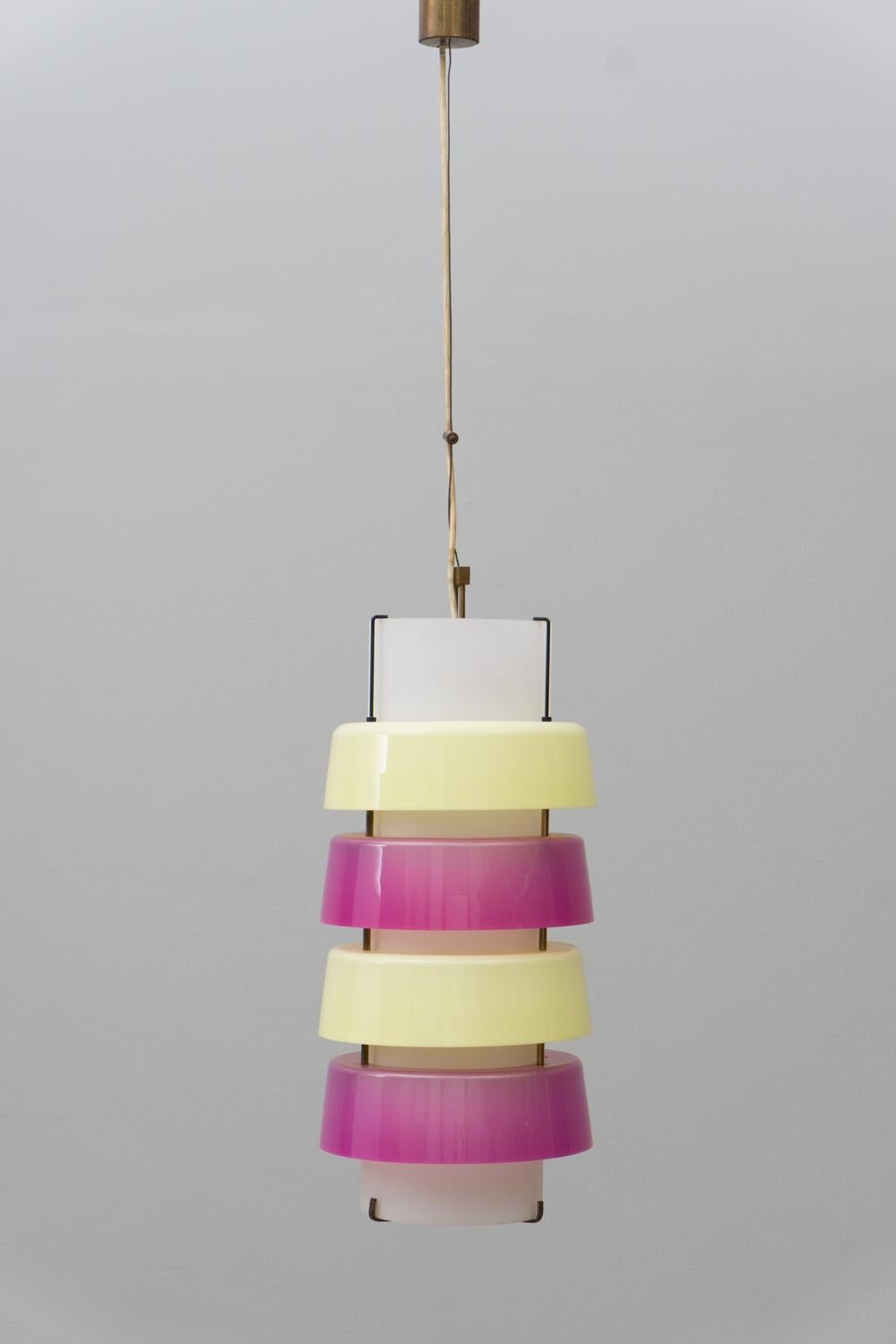 Playful pendant made of opaline glass and colored perspex in pink and yellow. Mounting made of brass. 
Labeled 'Stilnovo'.
  