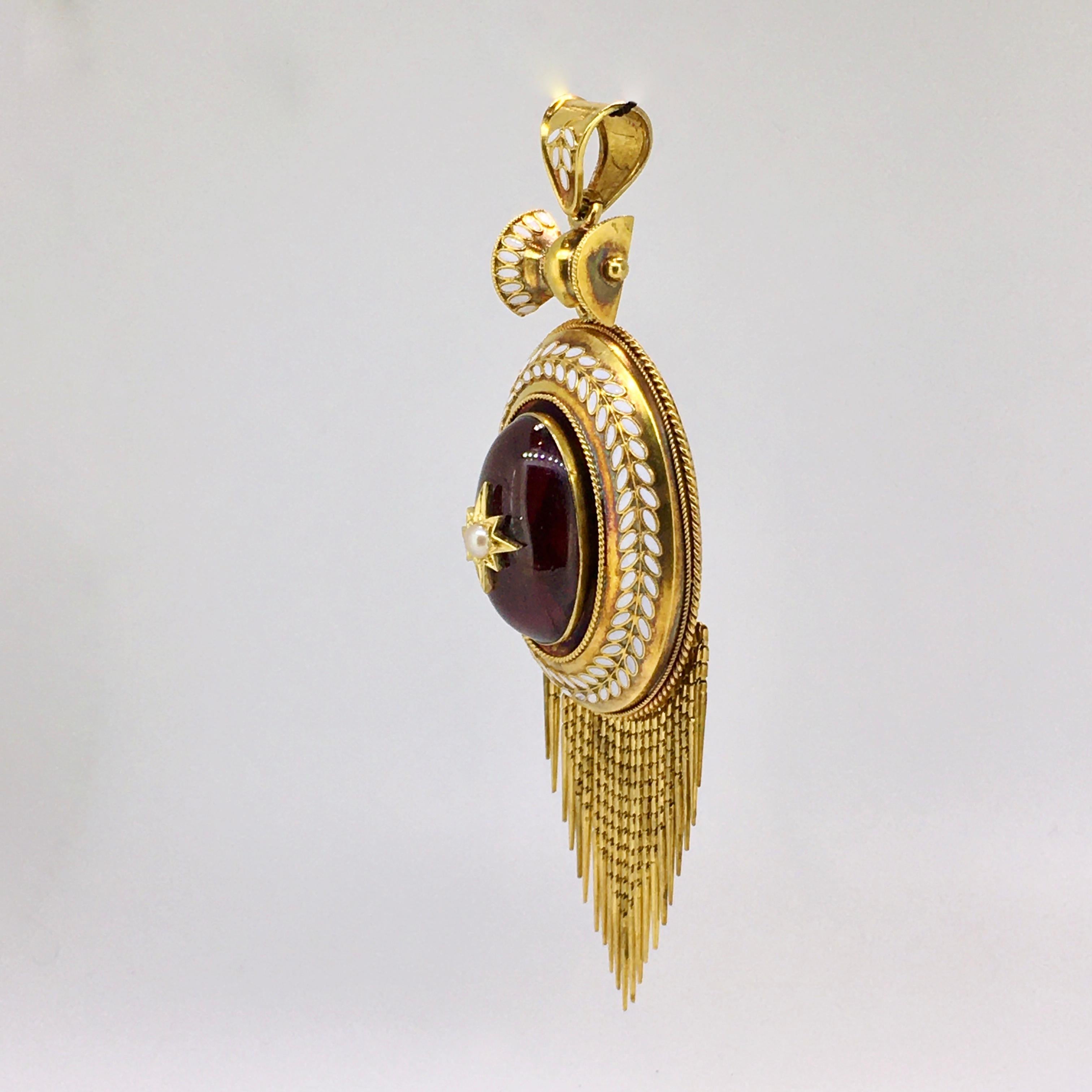 A beautiful Gold Victorian Pendant, set with Garnet cabochon, Enamel decorations, Pearl, 1860

Exquisite Victorian, pendant crafted in yellow gold measuring 94mm x 34mm. Fine white enameling decoration around the oval cabochon garnet, and on the