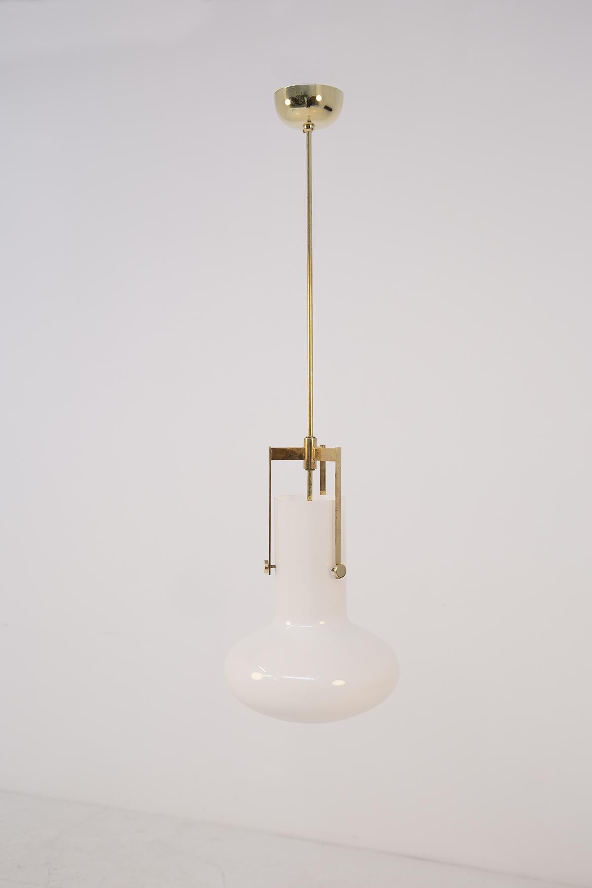 Elegant Italian pendant designed by Ignazio Gardella for Azucena in the 1960s. The wonderful pendant is made of brass with three lateral structures that support the white Opaline glass cap. The Opaline glass is supported by three brass screws that