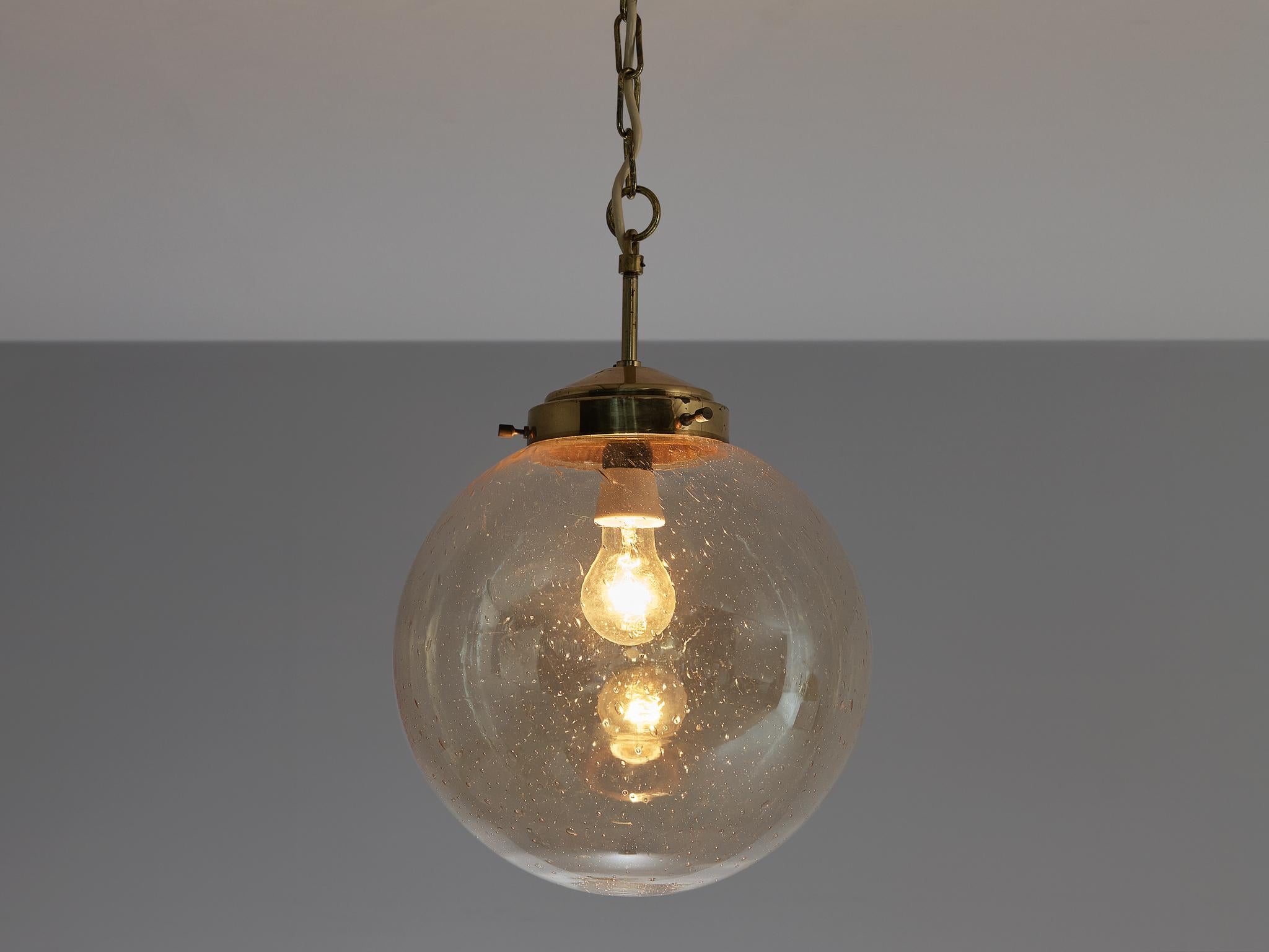 Pendant, brass, glass, Europe, 1970s

Blown glass pendant with multiple bubbles visible in the smoked glass orb. It not only gives the shade a playful appearance, it also creates a sparkling light partition. The canopy, stern and fixture are