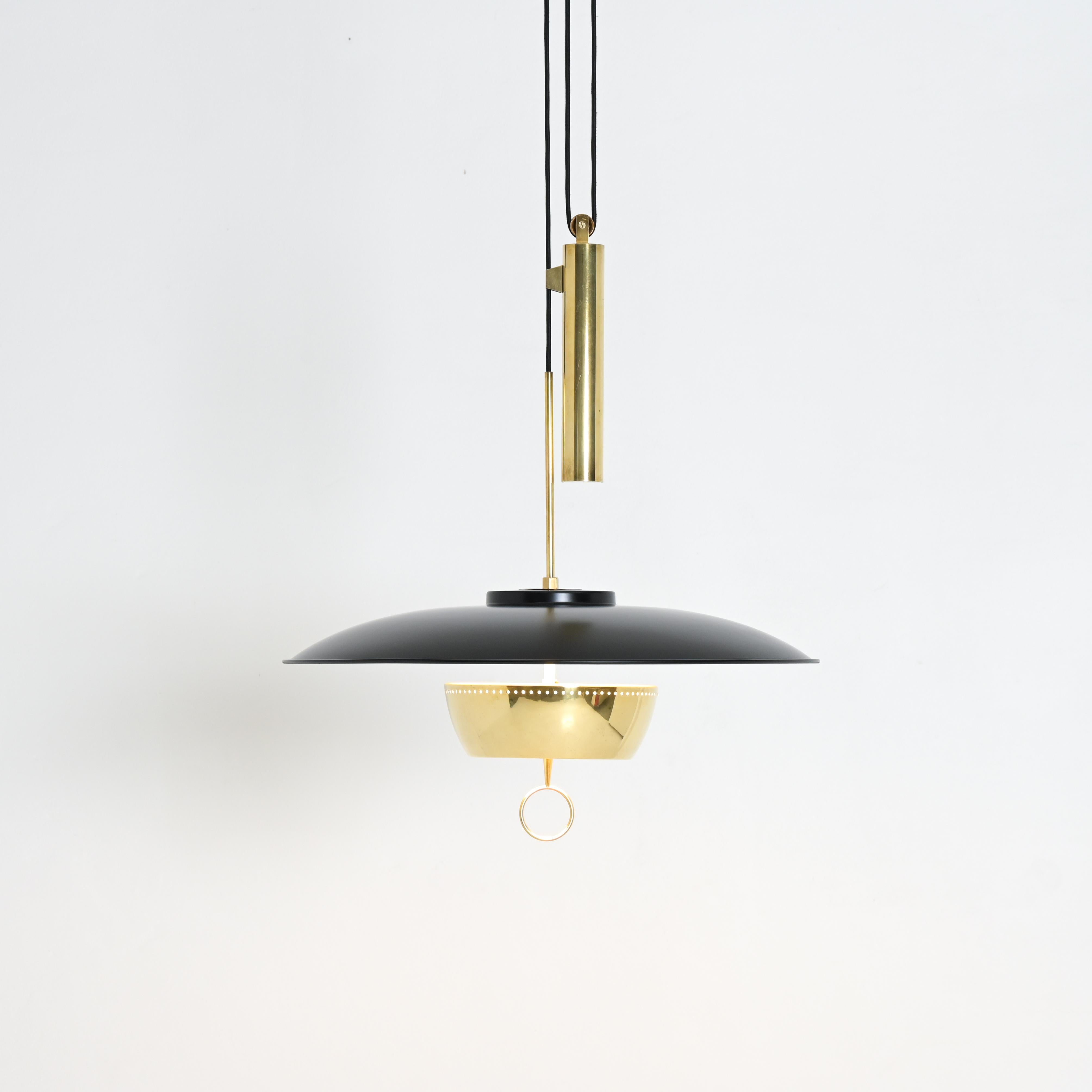 This elegant, dynamic, Mid-Century Modern pendant lamp A5011 was designed by Gaetano Scolari for Stilnovo in 1950. The lamp is made of metal, brass and glass. The height is adjustable with the counterweight. The white inside of the shade reflects