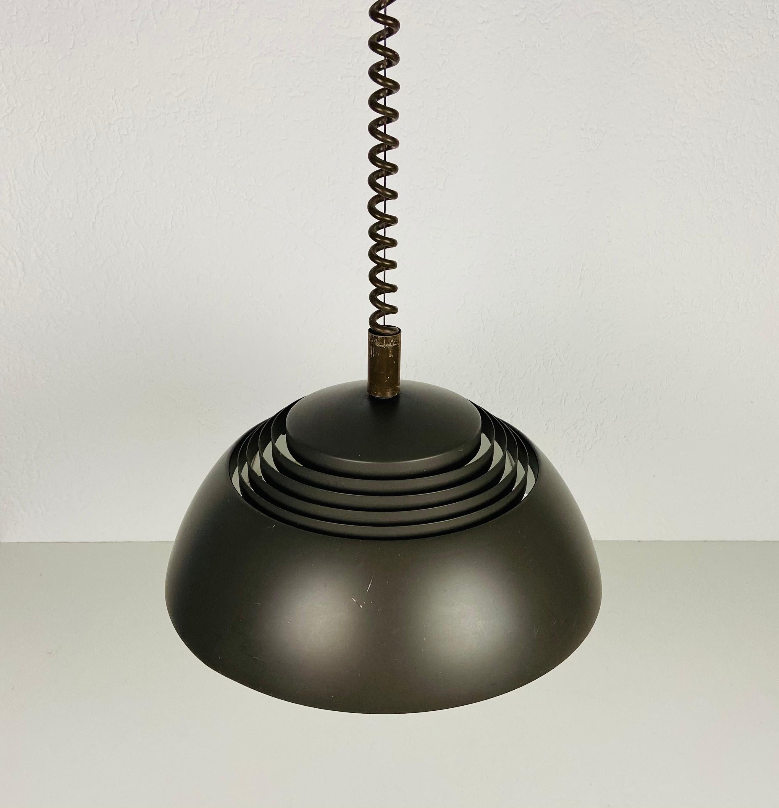 Rare lampe suspendue d'Arne Jacobsen fabriquée au Danemark dans les années 1960. Le luminaire donne une très belle lumière. Il est fait d'aluminium et de plastique fin. La hauteur est réglable.

Le luminaire nécessite trois ampoules E27 (US E26).