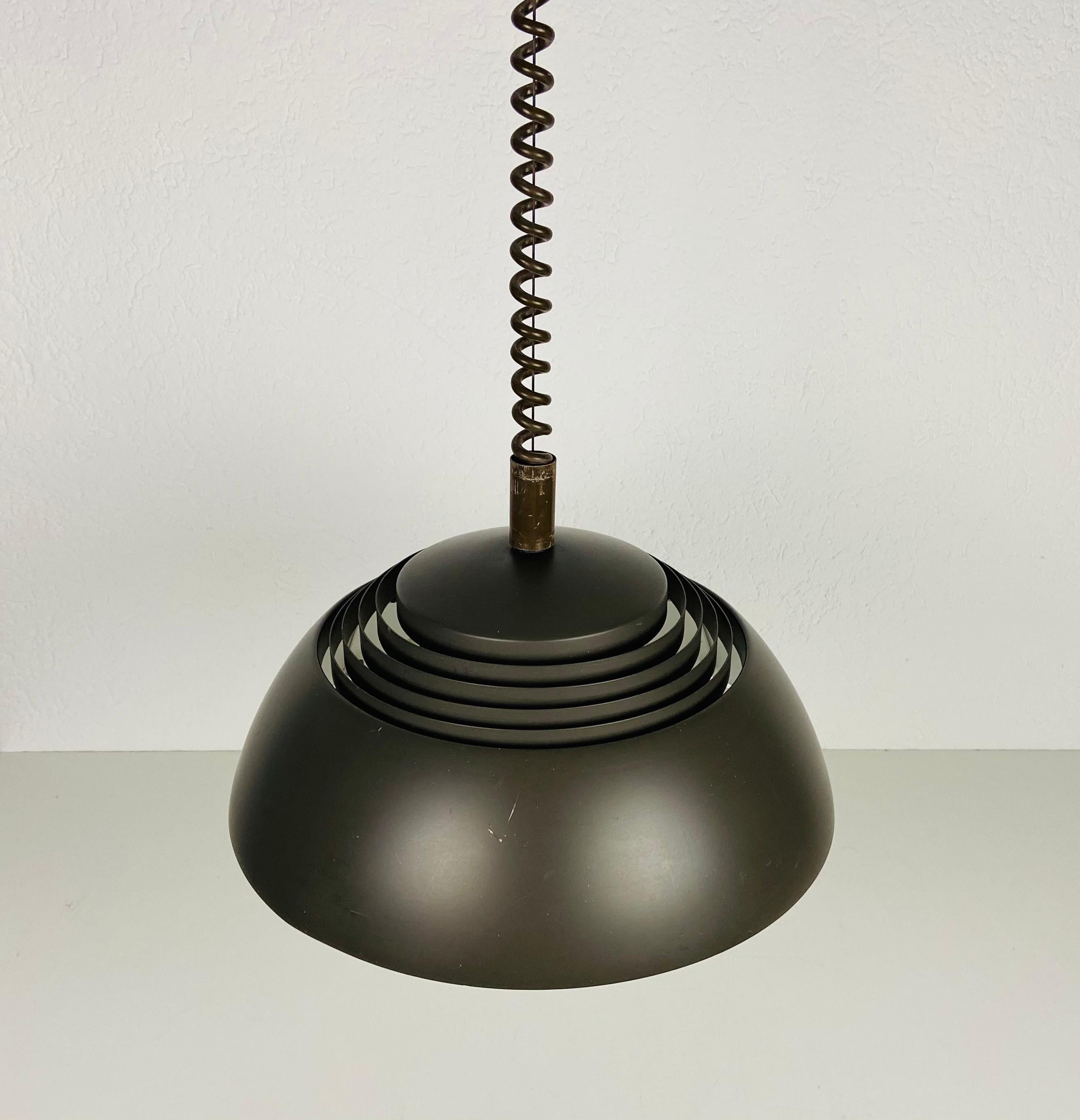 Rara lampada a sospensione di Arne Jacobsen, realizzata in Danimarca negli anni '60. L'apparecchio emette una luce molto bella. È realizzato in alluminio e plastica sottile. L'altezza è regolabile.

La lampada richiede tre lampadine E27 (US E26).