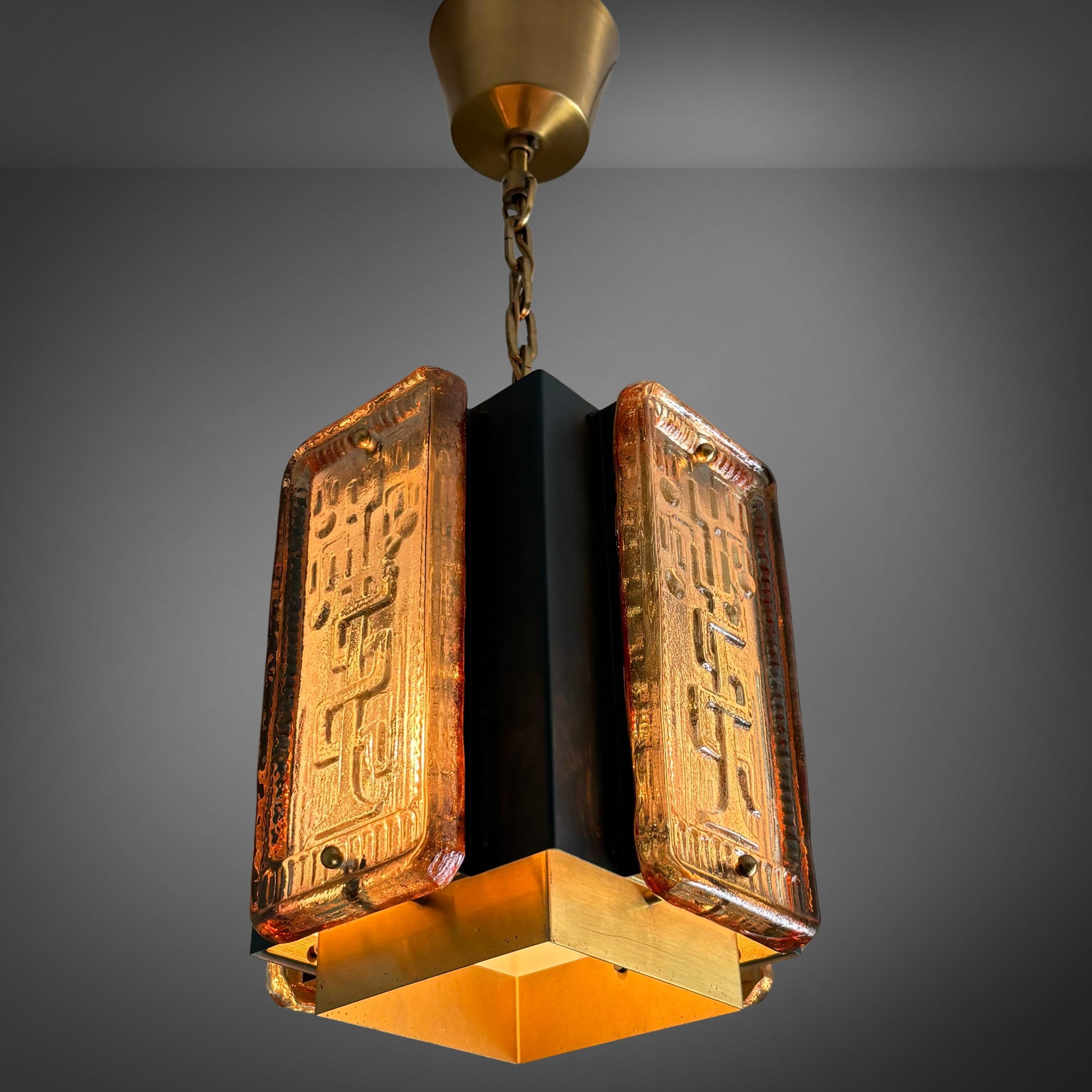A cube-shaped pendant lamp produced by the Swedish manufacturer Einar Bäckströms Metallvarufabrik in the 1960s. Crafted from steel and brass with decorative glass reliefs depicting the snake in the Tree of Eden, the glass is attributed to the