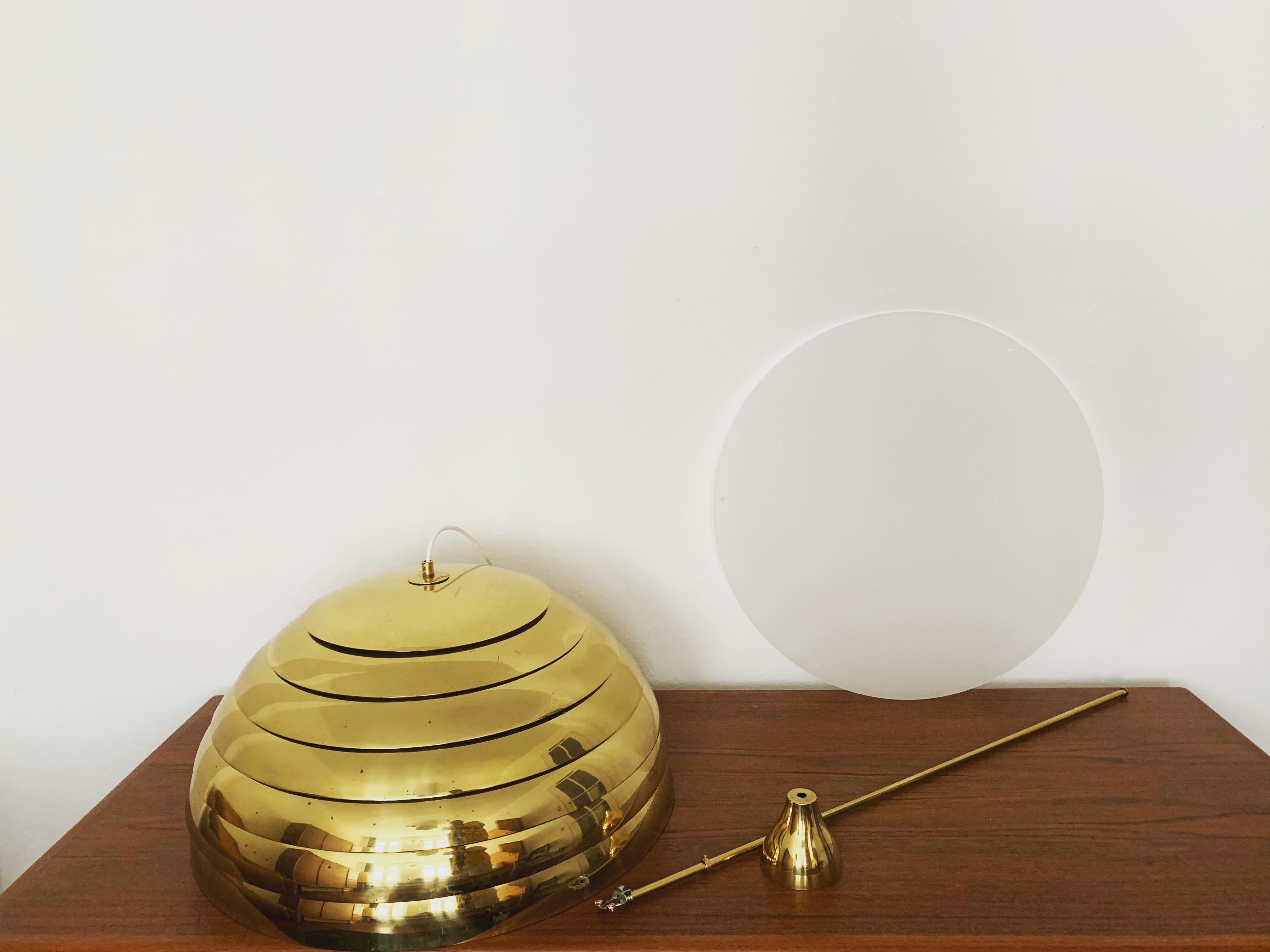 Impressive large brass lamp from the 1960s.
Extraordinarily successful design and very high-quality workmanship.
The brass hemisphere with the slats spreads a pleasant lighting atmosphere.

Manufacturer: Vereinigte Werkstätten