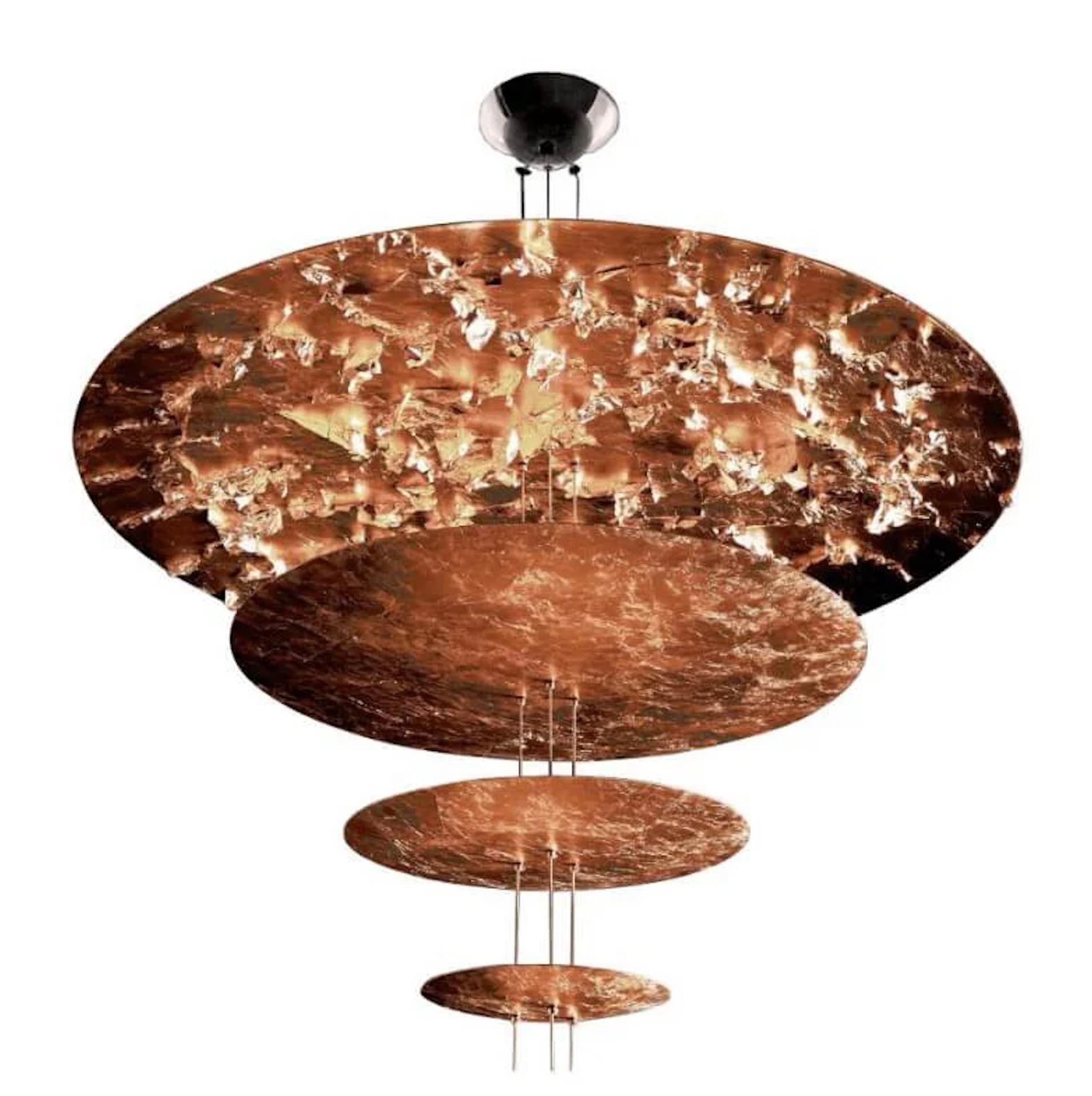 La Macchina della Luce, che fa parte della collezione Luci d'Oro di Catellani & Smith, nasce da una riflessione sul colore della luce, dorato come il sole e il fuoco. Questi toni caldi ispirarono Enzo Catellani a indagare il concetto di rifrazione,