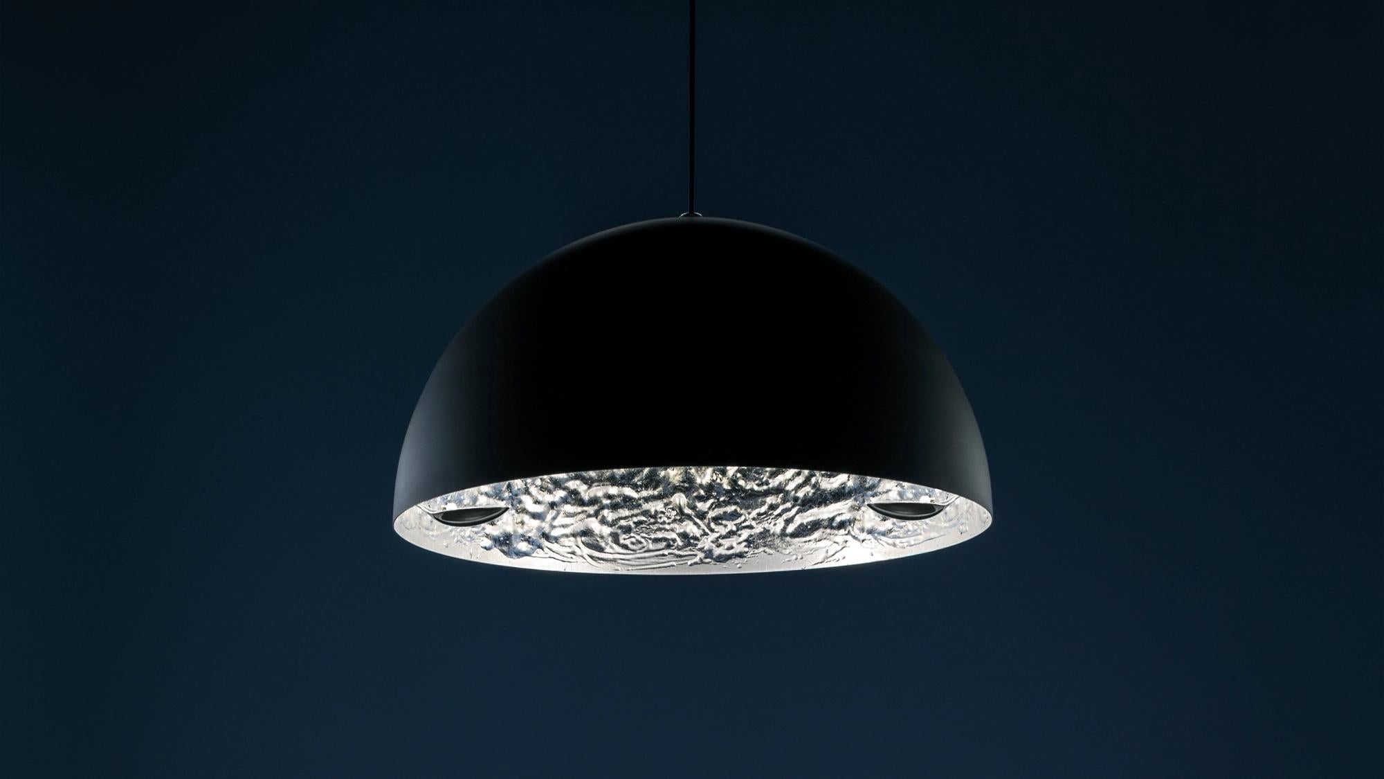 El Stchu-Moon 02, diseñado por Catellani & Smith, transforma la luz en una experiencia escultórica. Sus superficies internas irregulares reflejan y multiplican la luz, creando un objeto luminoso de presencia impactante y