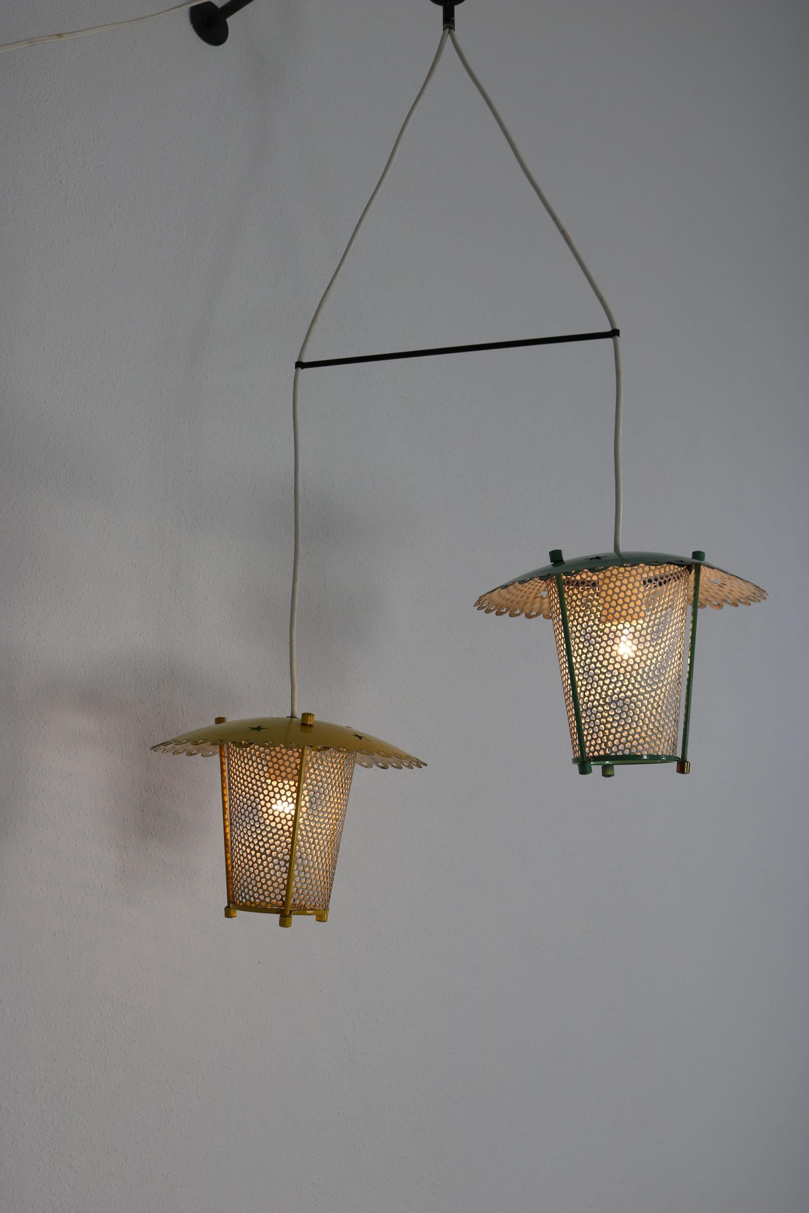 Pendant lamp consisting of two lanterns. The two aluminium lanterns with punched out stars are lacquered in yellow and turquoise. Due to the perforated metal shade, the light casts a beautiful shadow pattern. The Italian lamp from the 50s has been