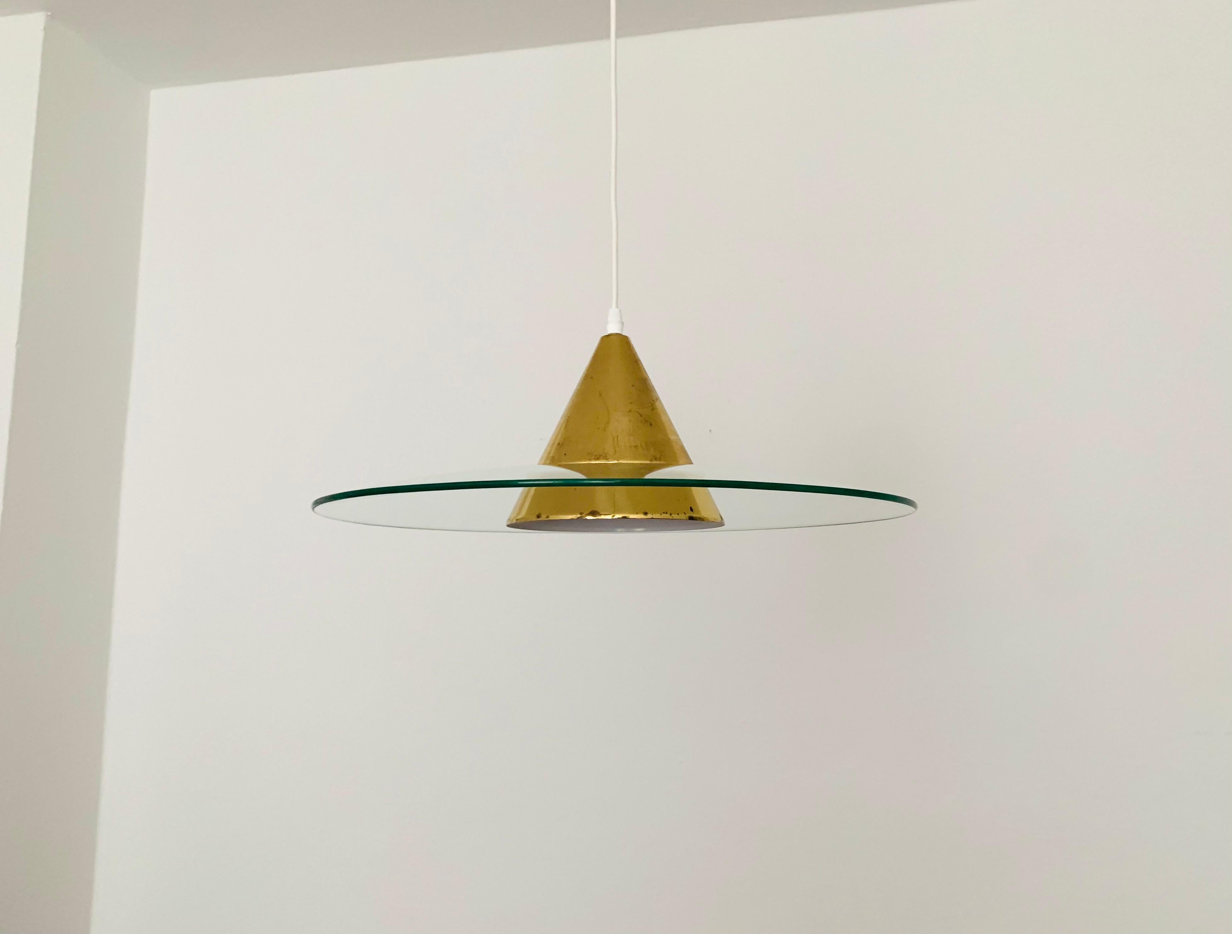 Impressive pendant light from the 1960s.
The design and the appearance of the lamp is particularly beautiful.
The glass is illuminated through the light slits in the aluminum cone.
A very special light effect is created.

Condition:

Very